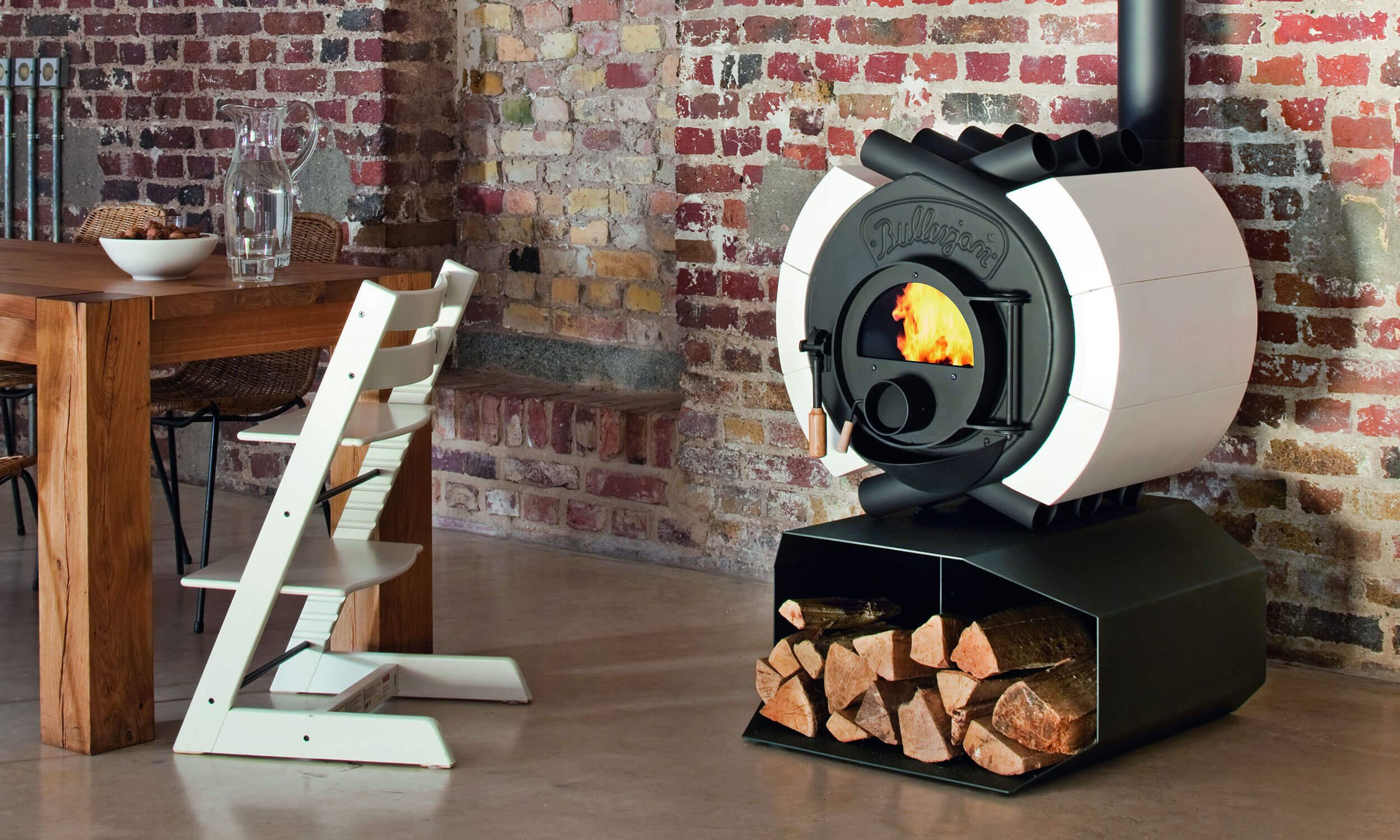Der klassische Bullerjan Free Flow Kaminofen mit Keramik-Verkleidung auf Podest bei Kaminwelt Hennef.