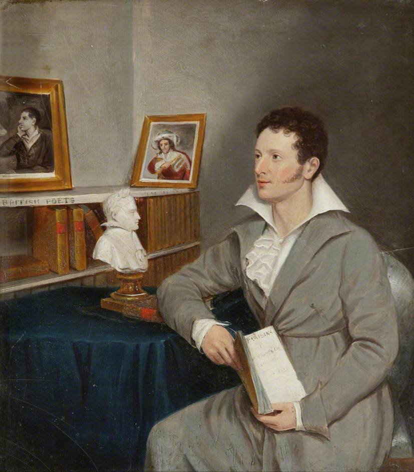 A young man with dark curly hair and sideburns, dressed in early 19th-century attire, sitting in a room with a book in his hand, surrounded by framed portraits and a bust on a shelf.