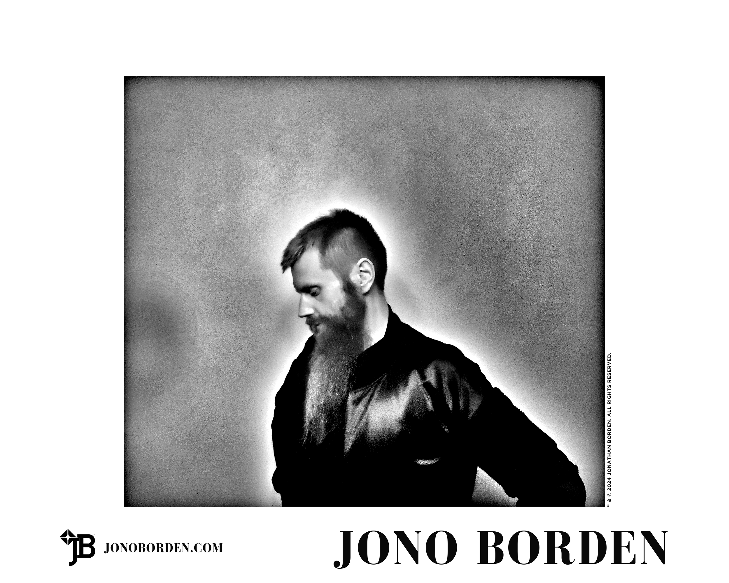 Black-and-white self-portrait of Jono Borden in profile, from the waist up, facing the left side of the frame, with his head down and his hands on his hips, wearing a satin jacket, a serious expression, and a very long groomed beard, taken in 2020.