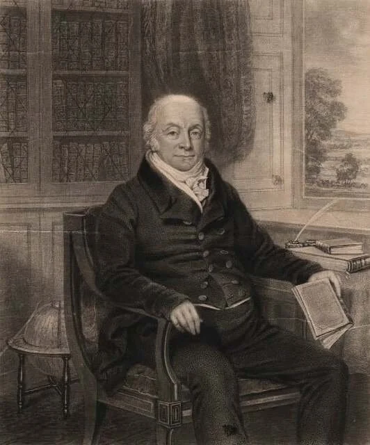 A black and white painting of a man sitting in a chair in a study, with bookshelves and a window in the background.