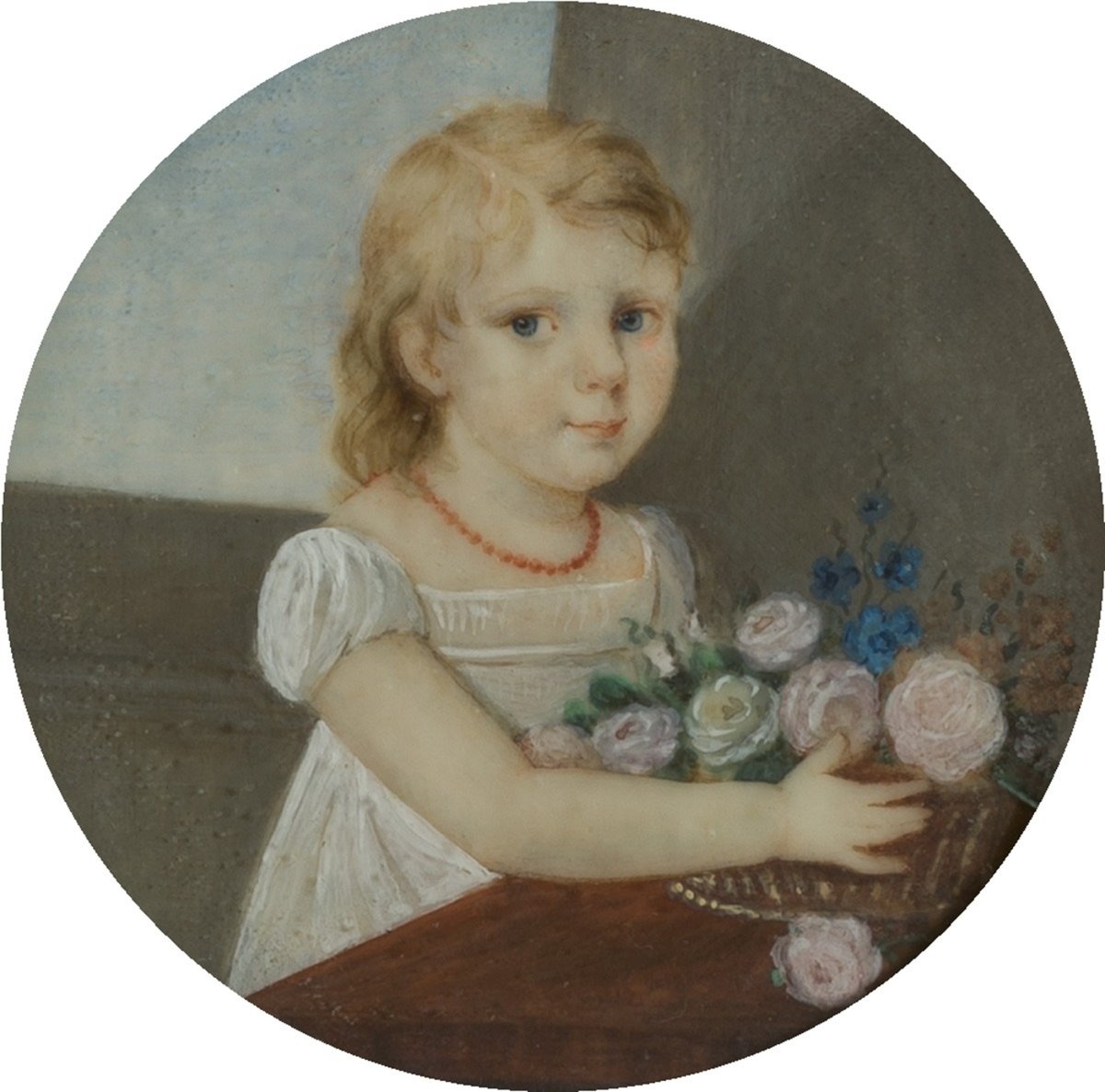 A young girl with blonde hair, blue eyes, wearing a white dress and red necklace, sitting at a table with a bouquet of pink and blue flowers.
