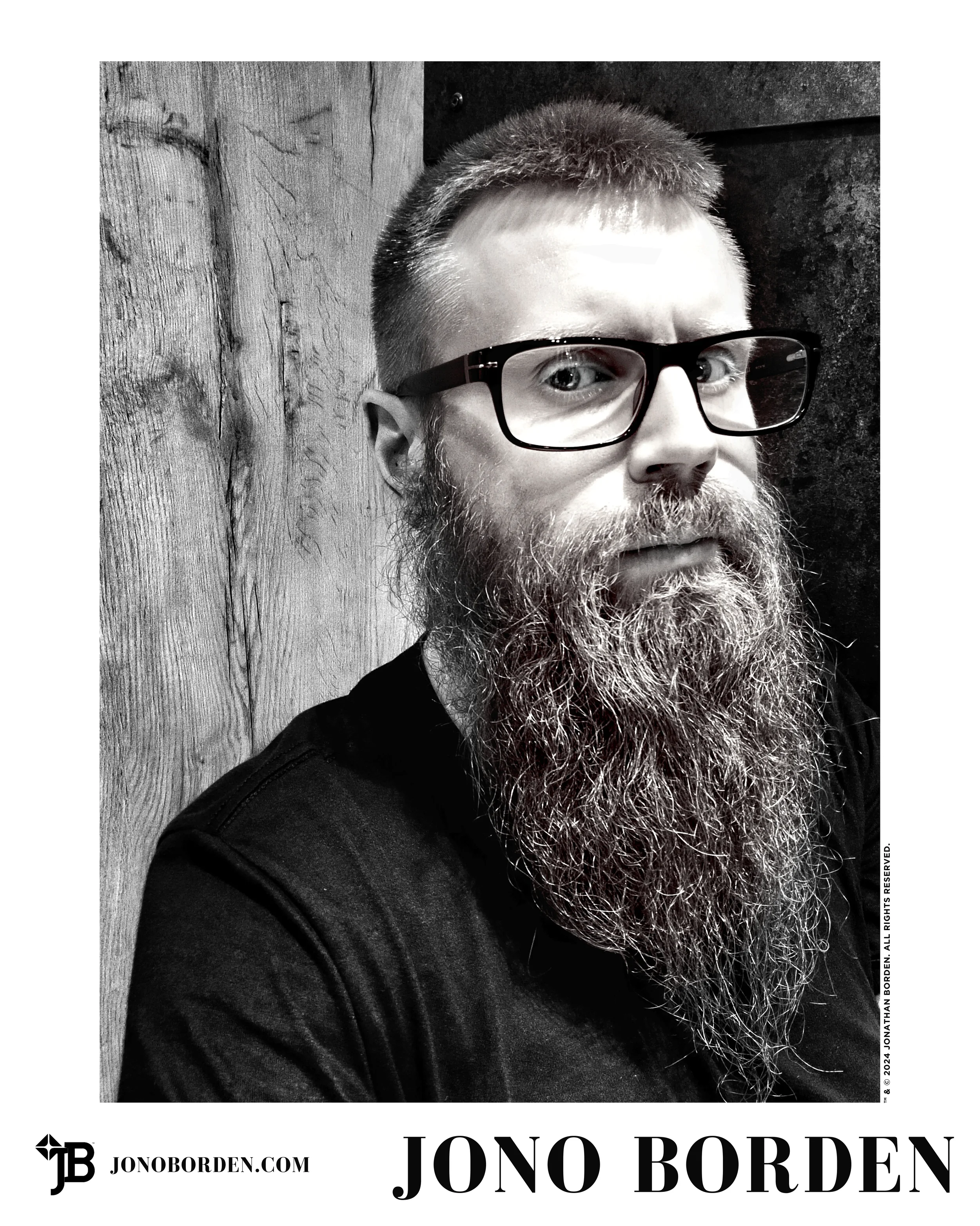 Black-and-white self-portrait of Jono Borden turned to face the camera, wearing glasses, with a solemn expression, looking directly at the viewer, taken of himself in 2024.