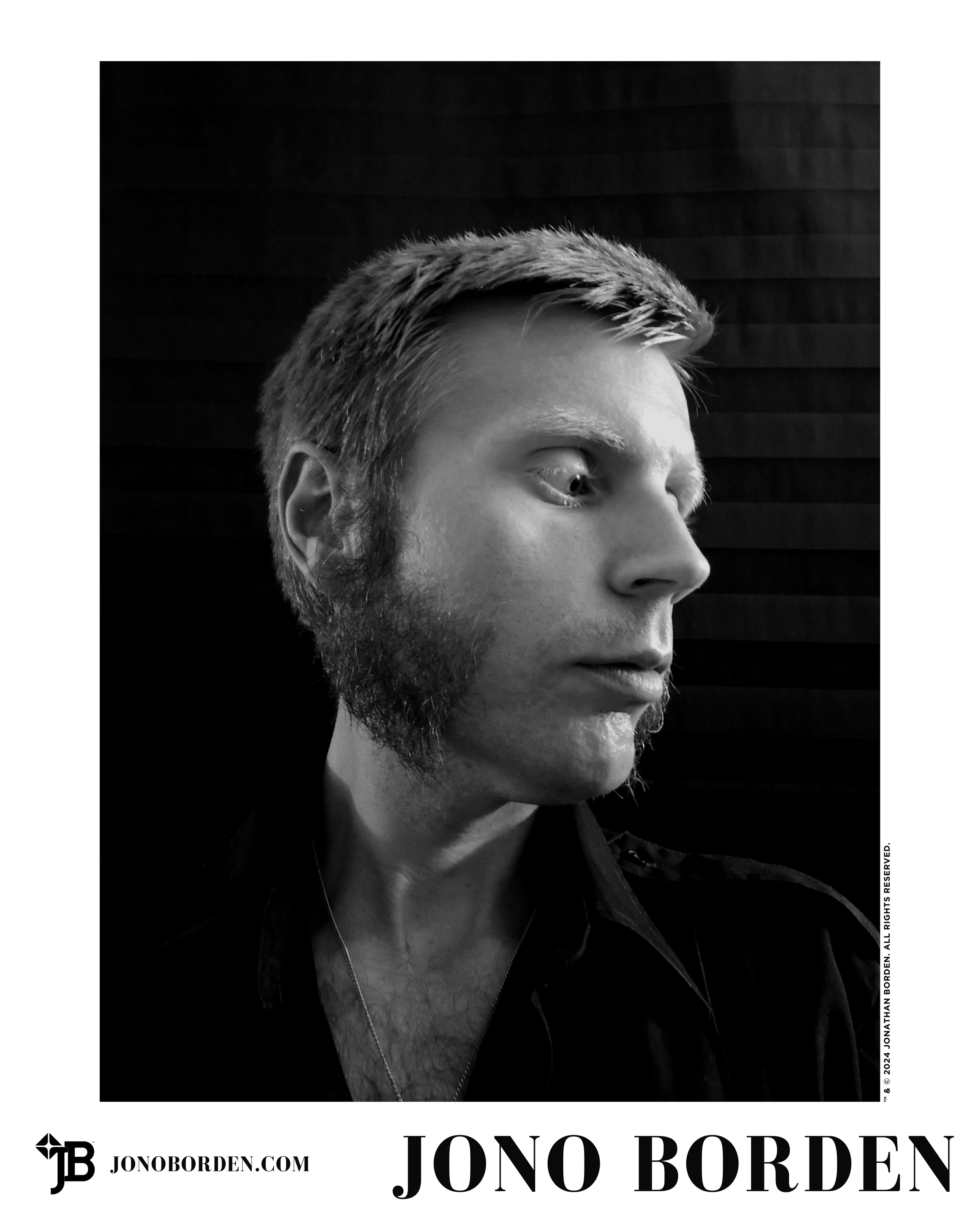 Black-and-white self-portrait of Jono Borden in a tight shot from the chest up, wearing a military uniform shirt with its collar unbuttoned, open, exposing chest hair and silver necklace, facing right of frame, with large mutton chops, taken in 2016.