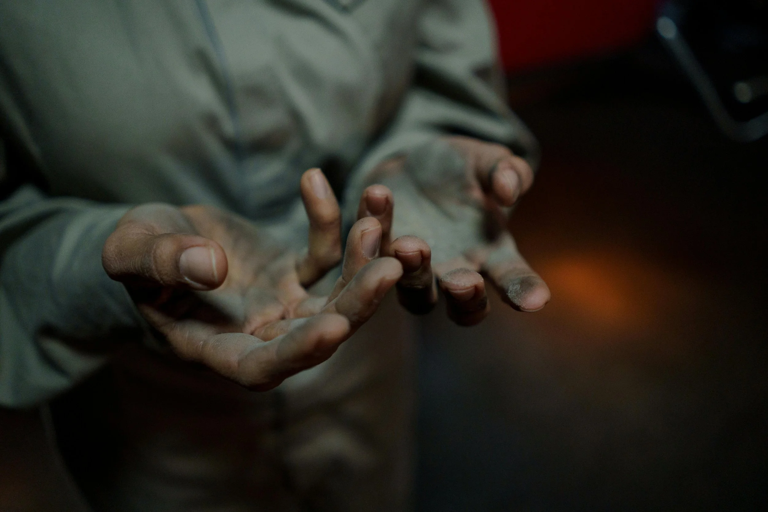 A close-up shot of dirty hands, both palms held open, showing that a man has been digging in the dirt and has nothing to offer but his effort.