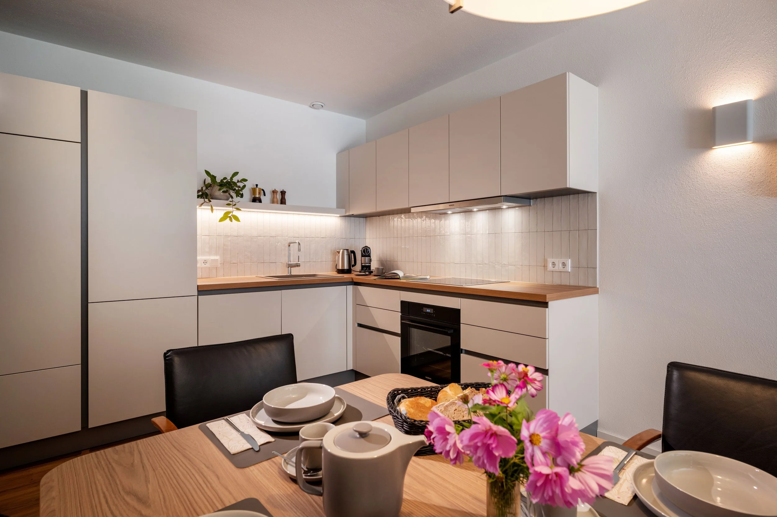Kuche mit Kochfeld, Backofen, Kühlschrank mit Gefrierfach, Kaffeemaschine, Nespresso, Bialetti, Wasserkocher, Weingläser, Pfannenset und Kochgeschirr.