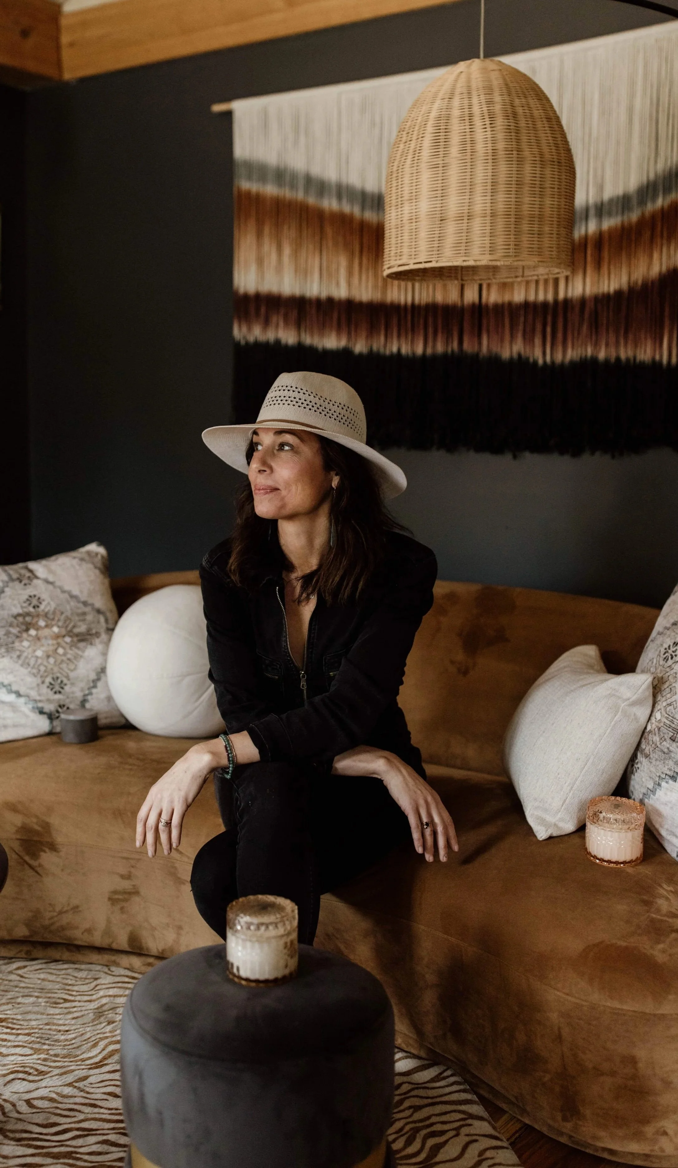 Opal & Fawn founder Anne Holloway sitting in her living room surrounded by her hand poured candles.