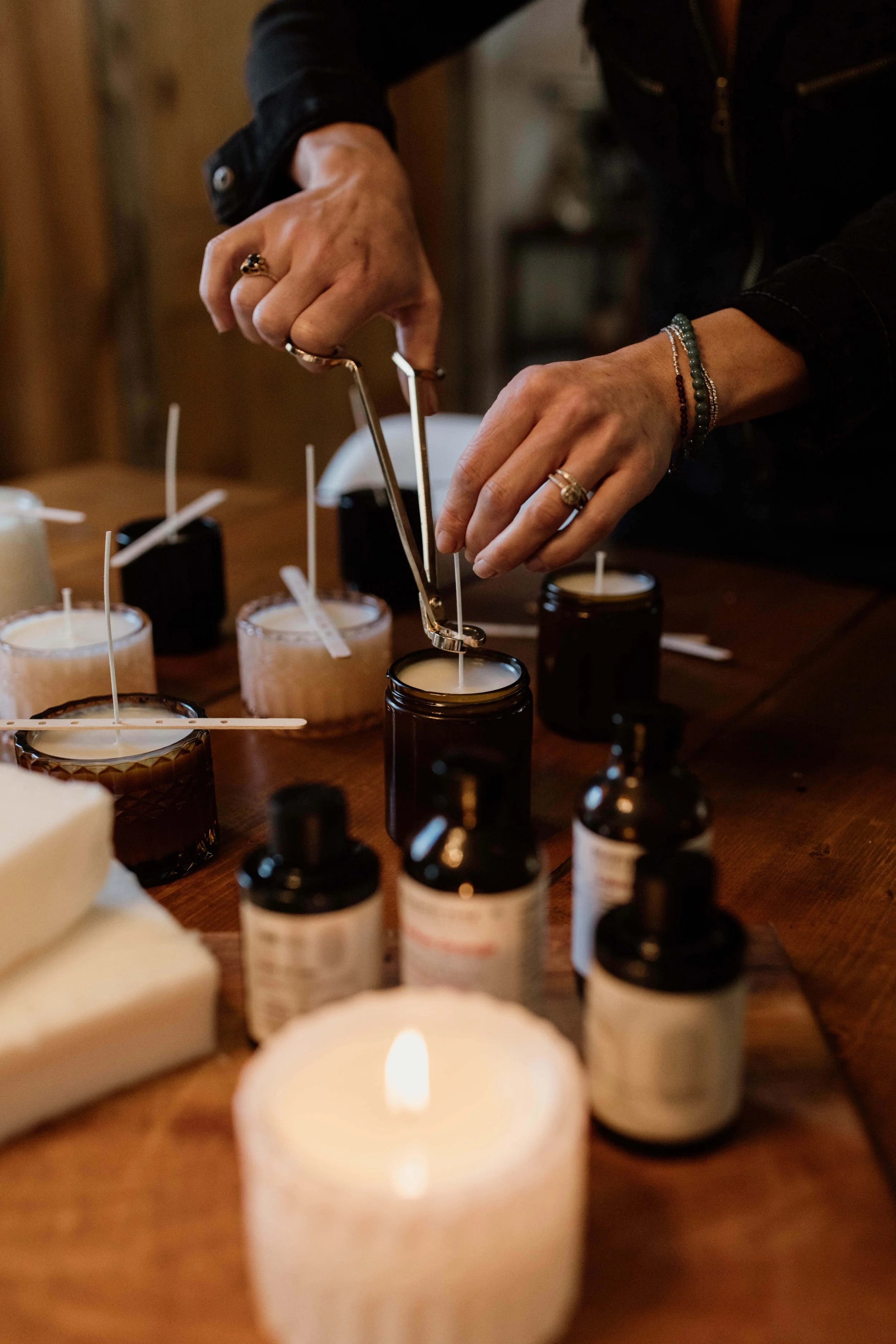 Anne adding the wick to the candle wax.