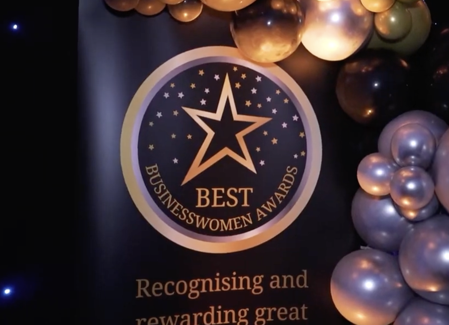 Businesswomen Awards logo with gold and silver balloons surrounding it.