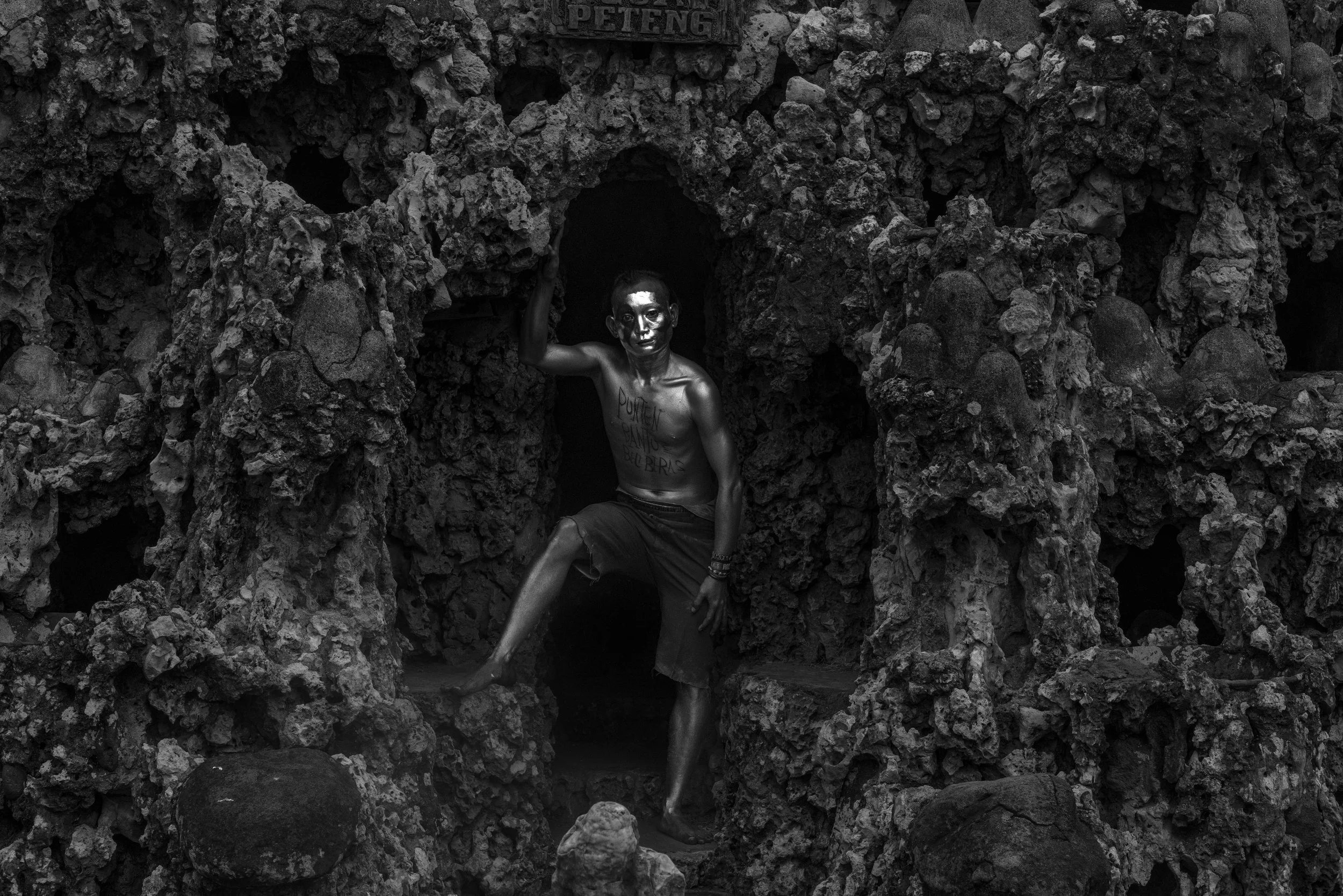 A Manusia Silver standing at the entrance to the mystical Sunyaragi Cave in Cirebon, West Java