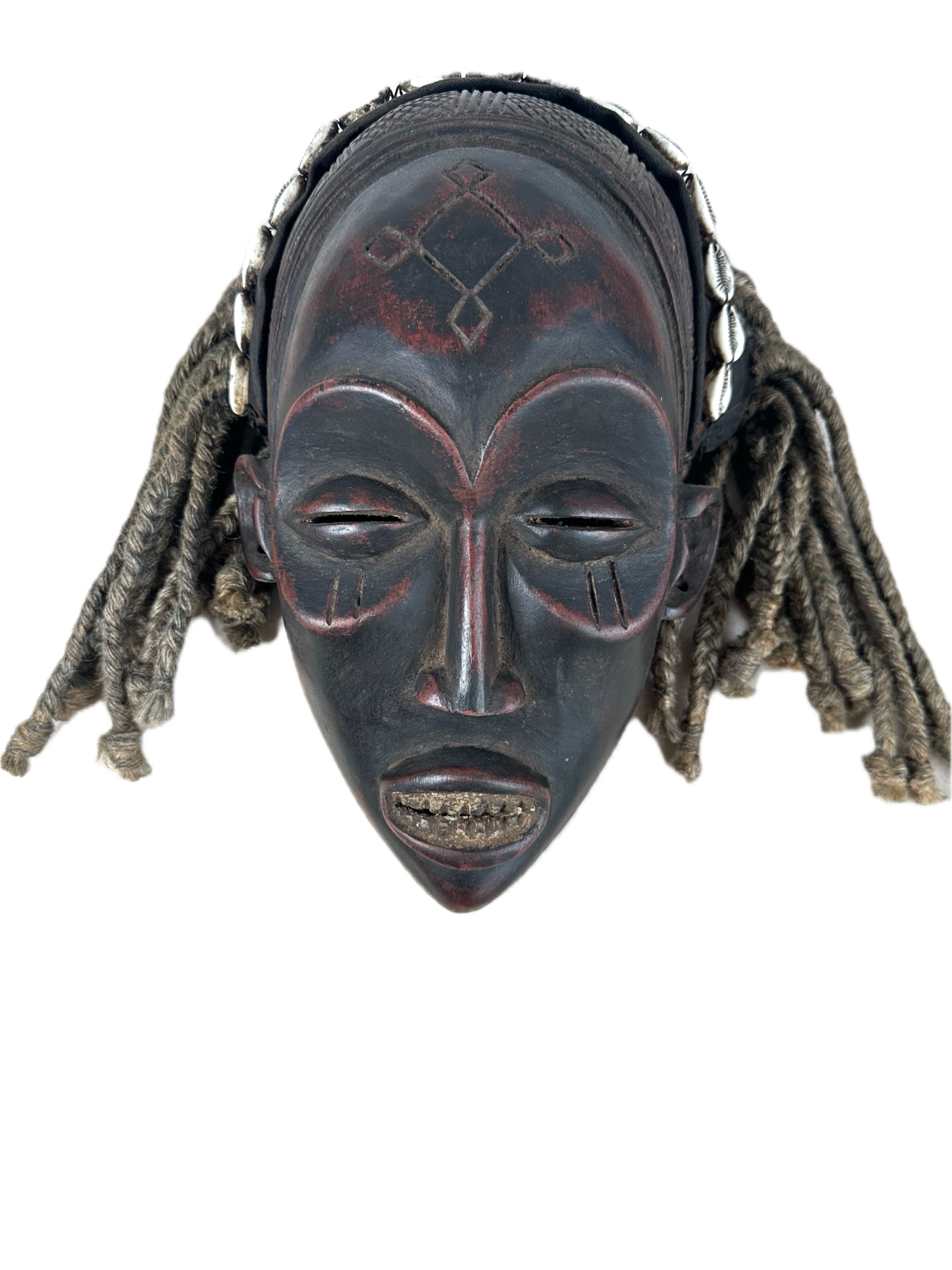 Chokwe – Maske mit Kaurimuscheln und Faserschnuck
Angola / DR Kongo, 20. Jahrhundert. Höhe ca. 30 cm.
Ausdrucksstarke Chokwe-Maske getragen bei rituellen Auftritten zur Vermittlung von Autorität, sozialer Ordnung und spiritueller Präsenz. 1.200 EUR