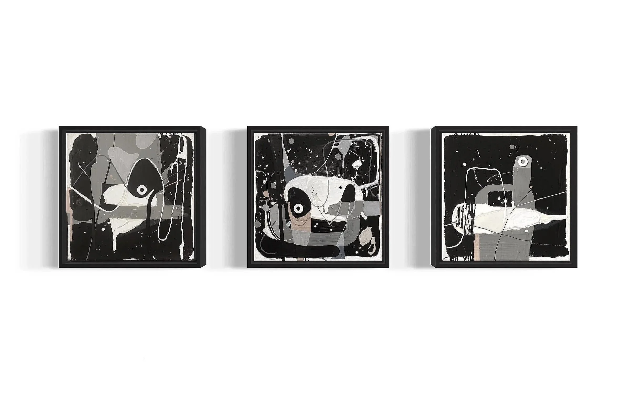 Triptych abstract paintings with black, white, beige, and orange splashes and shapes, framed and hung on a white wall.