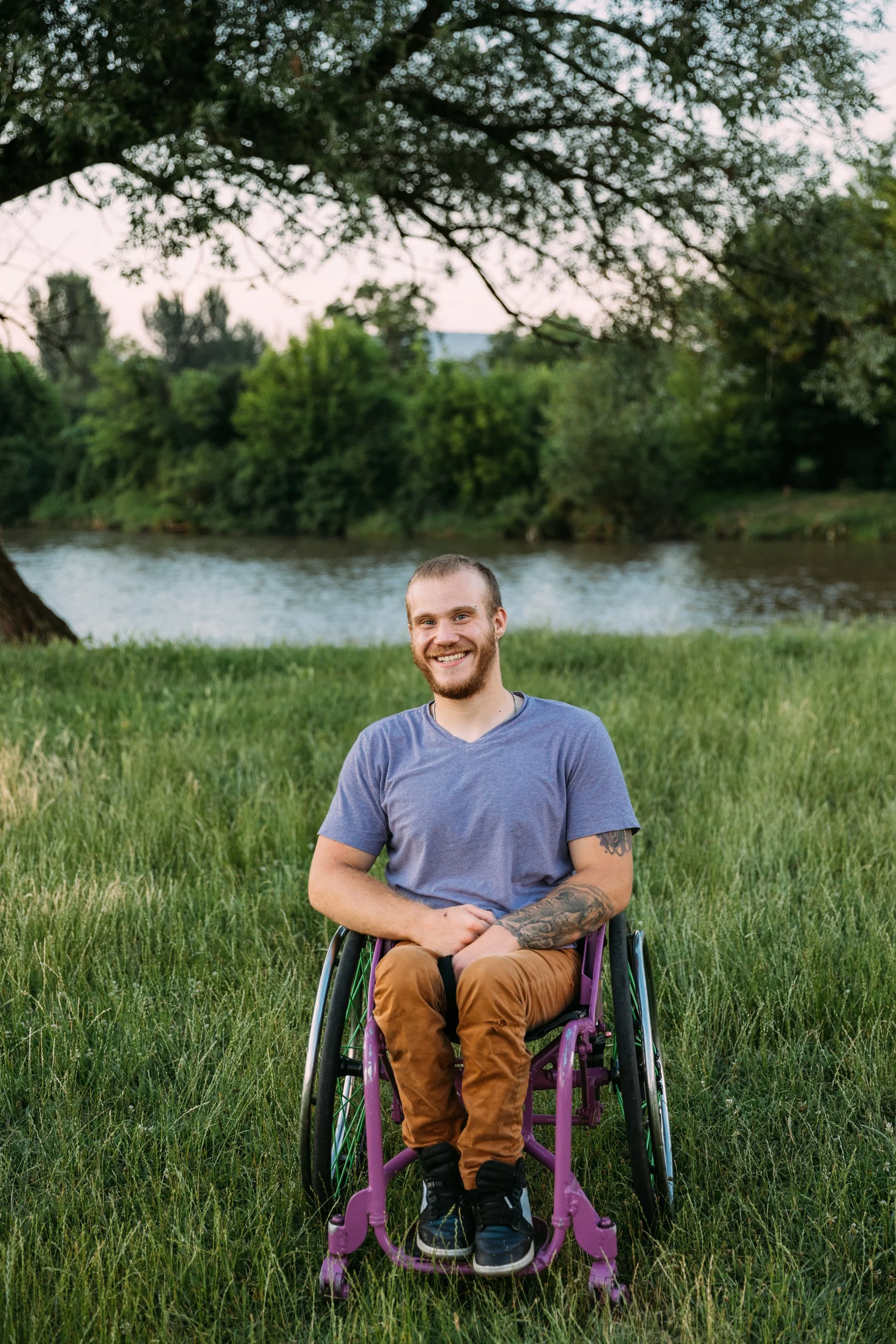 A man with a wheelchair smiling at the camera with his live in carer in Surrey
