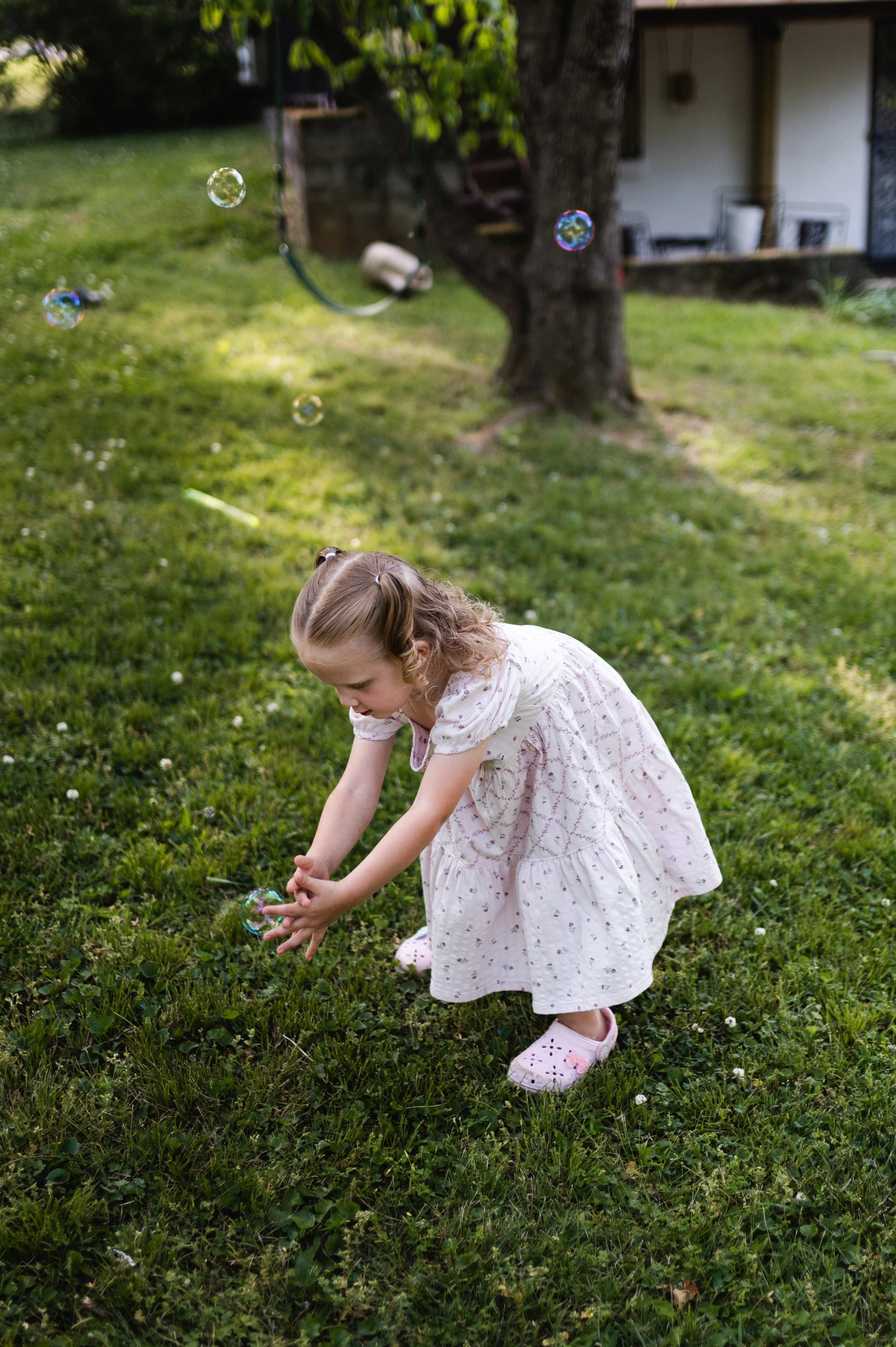girl popping bubbles in yard, motherhood photos, family photographer clarksville tn, affordable, family photographer nashville tn