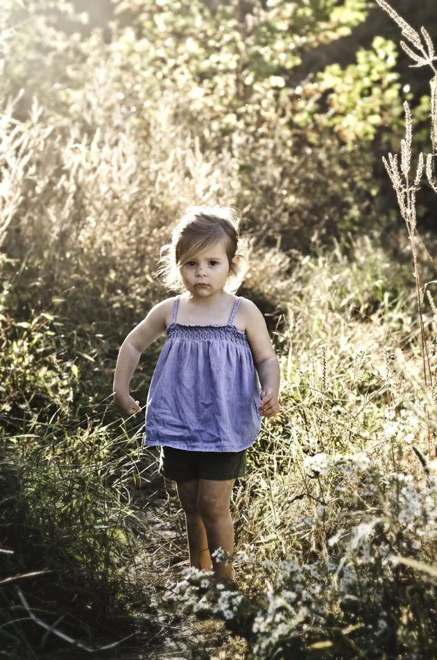 young girl wearing blue shirt stands in summer field at sunset, clarksville tennessee, nashville tennessee, photographer, milestone, birthday, family photographer, affordable