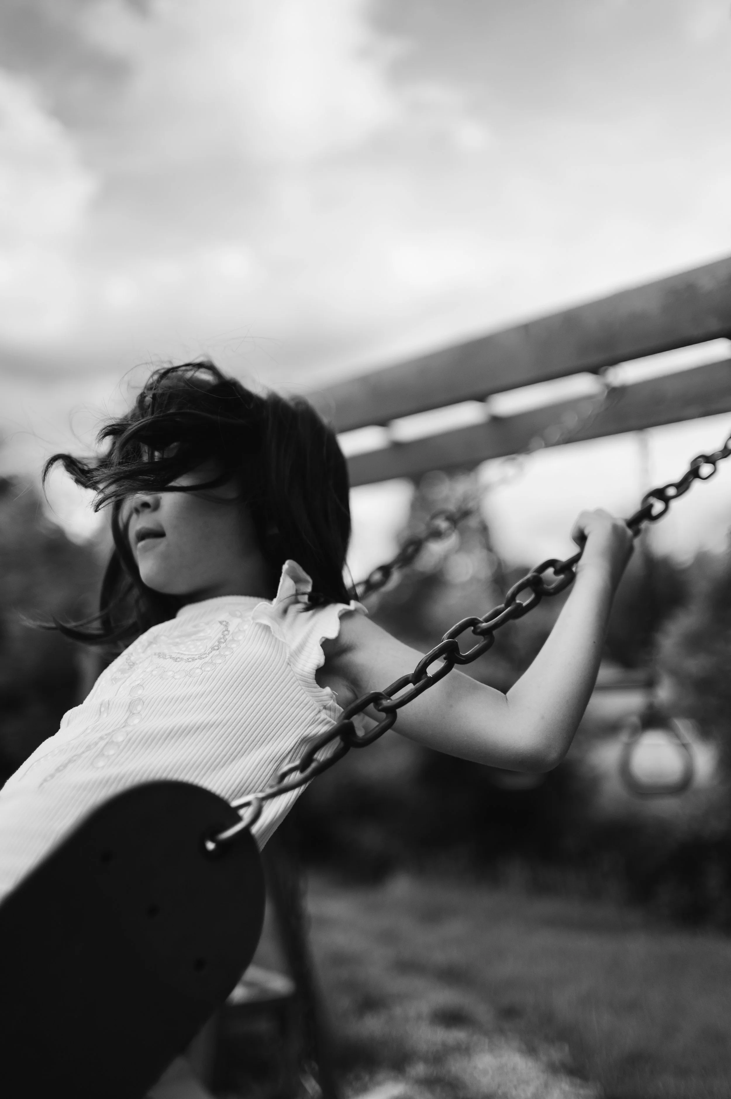black and white, young girl on swing with clouds, clarksville tennessee, cinematic, photographer