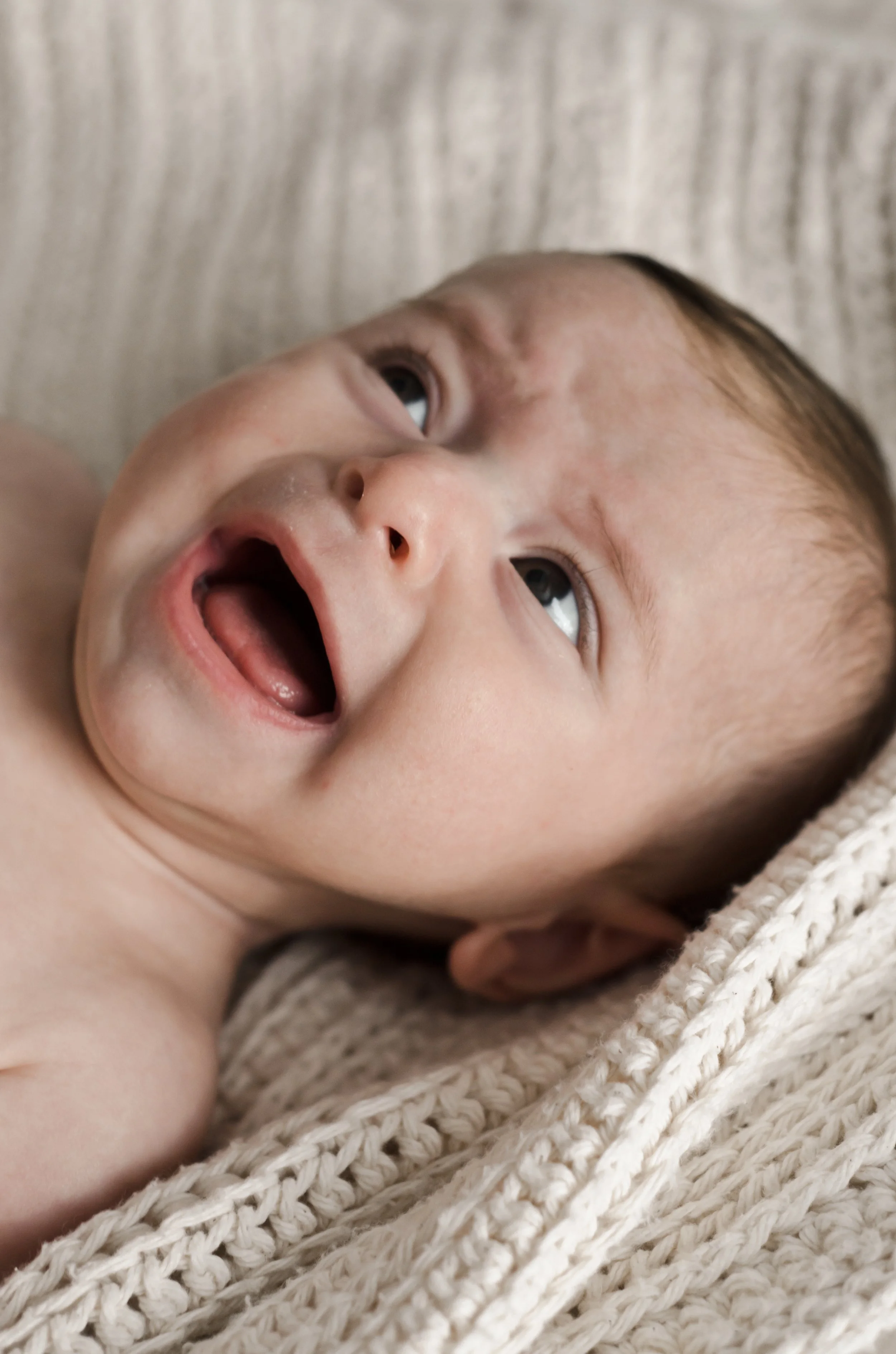 crying three month old baby lays on cream knit blanket, photographer, affordable, clarksville tn, nashville tn, newborn photographer, family photographer