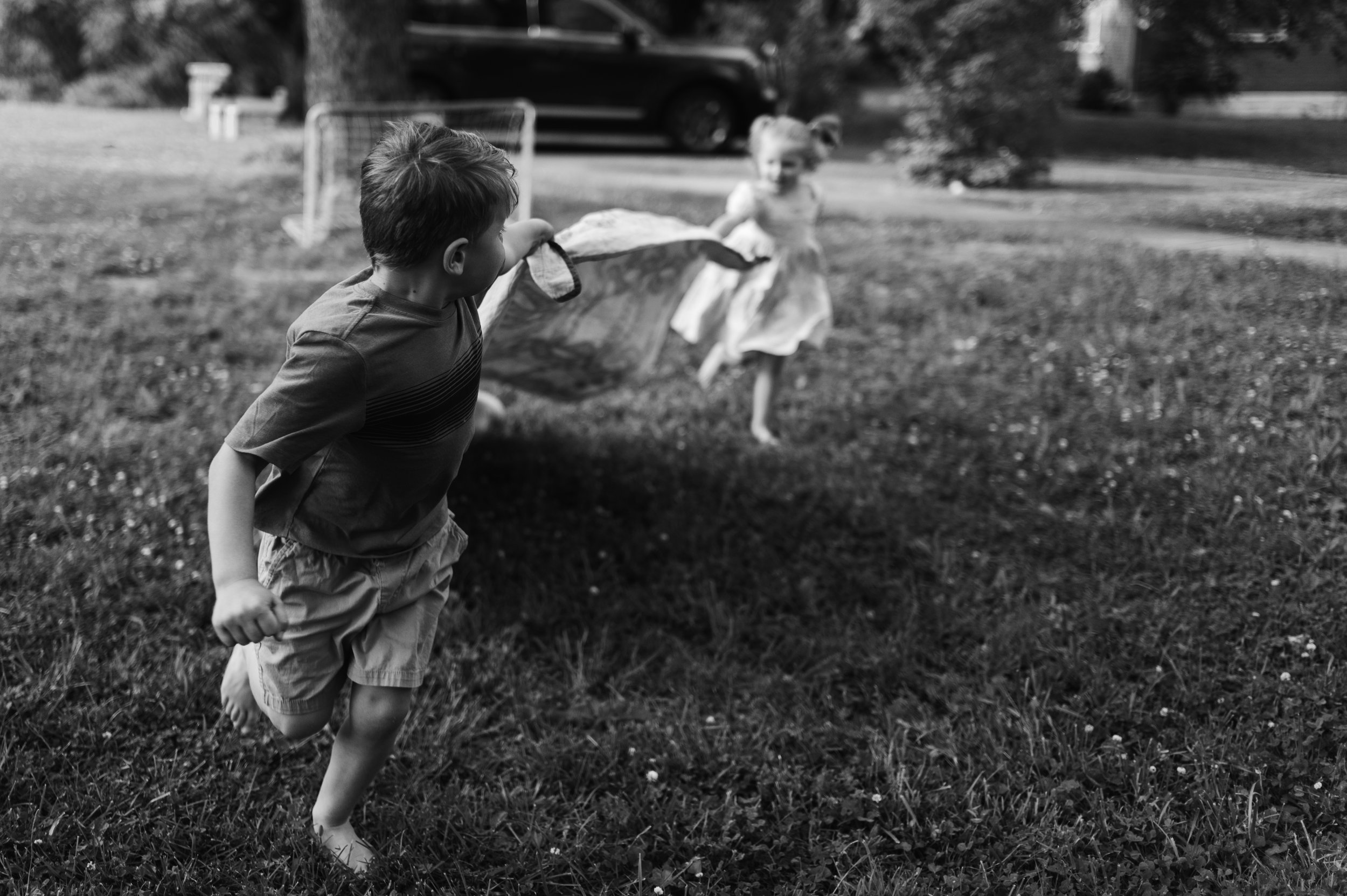 children play with blanket outside, candid family photos, storytelling family photos, clarksville tn, nashville tn, family photographer
