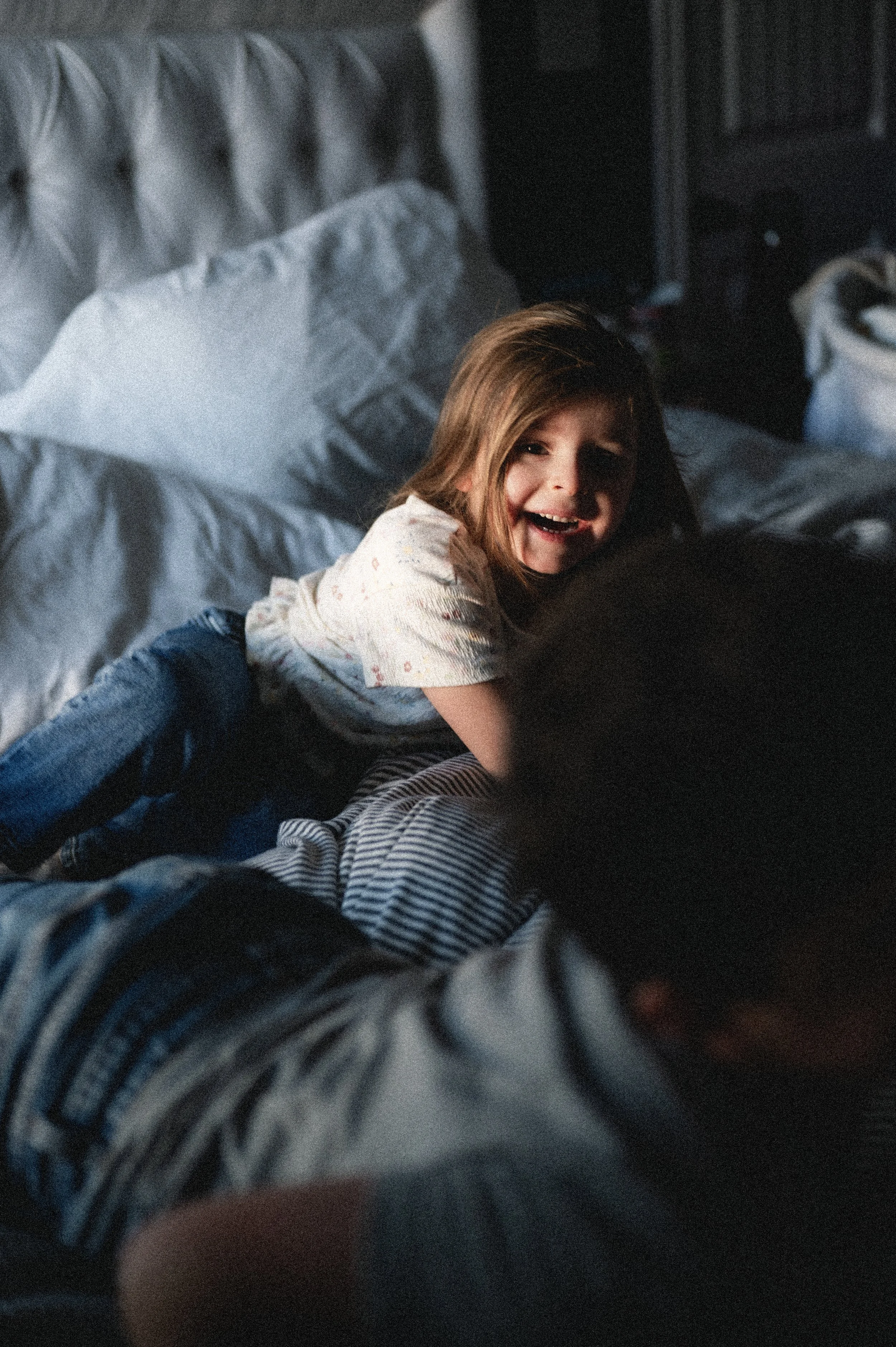 moody portrait of laughing young girl in bedroom, clarksville tn, nashville tn, photographer, affordable, in-home family photographer, documentary