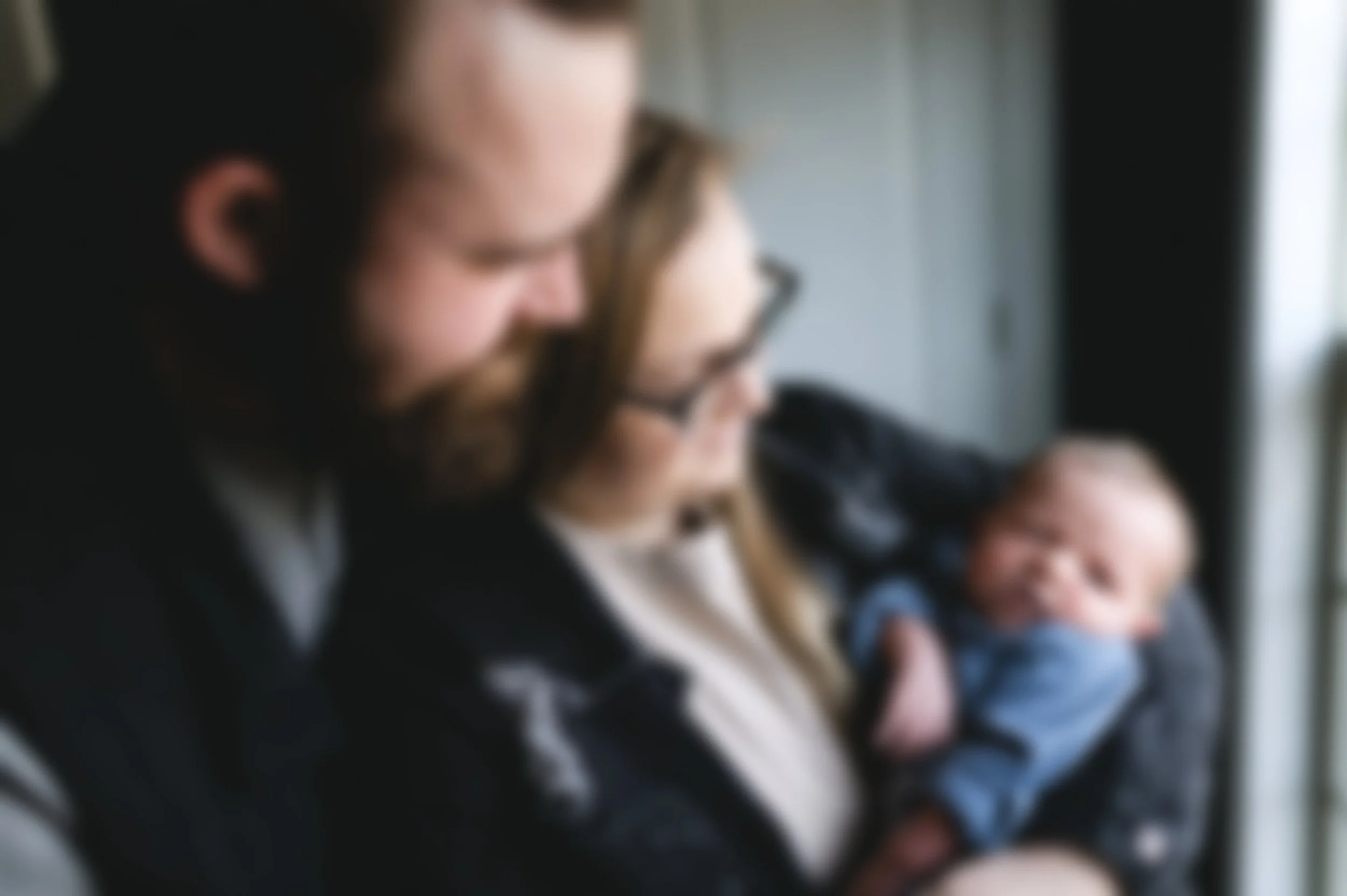 man and woman in dark clothes holding newborn baby, newborn photographer, photographer, affordable, clarksville tn, nashville tn, film photographer, documentary newborn photography, at-home newborn session