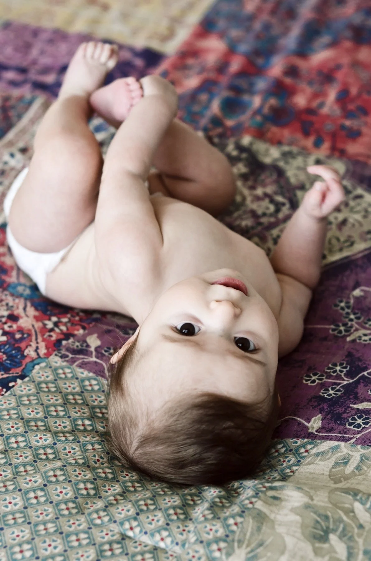 baby girl lays on colorful patterned blanket, clarksville tennessee, nashville tennessee, photographer, affordable, newborn, milestone, motherhood, lifestyle, photography, family