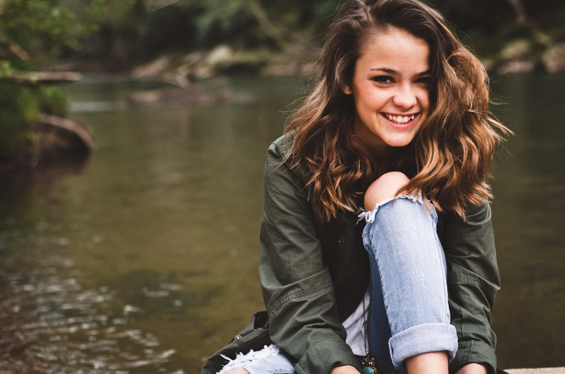 brunette-senior-portrait-spring-river-happy.jpg