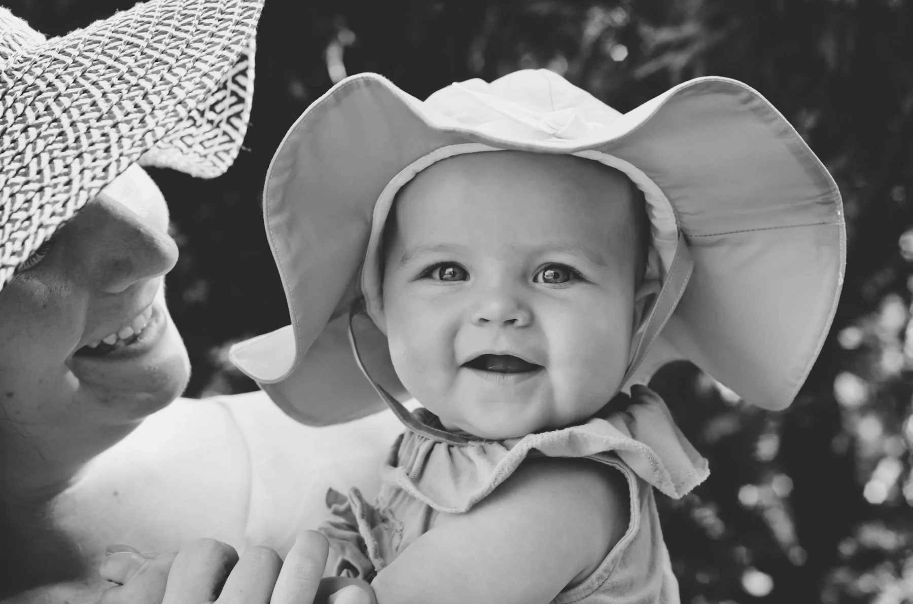 black and white photo of smiling mother holding baby girl wearing sunhat, family photographer, newborn photographer, baby photos, film photographer, affordable, nashville tennessee, clarksville tennessee
