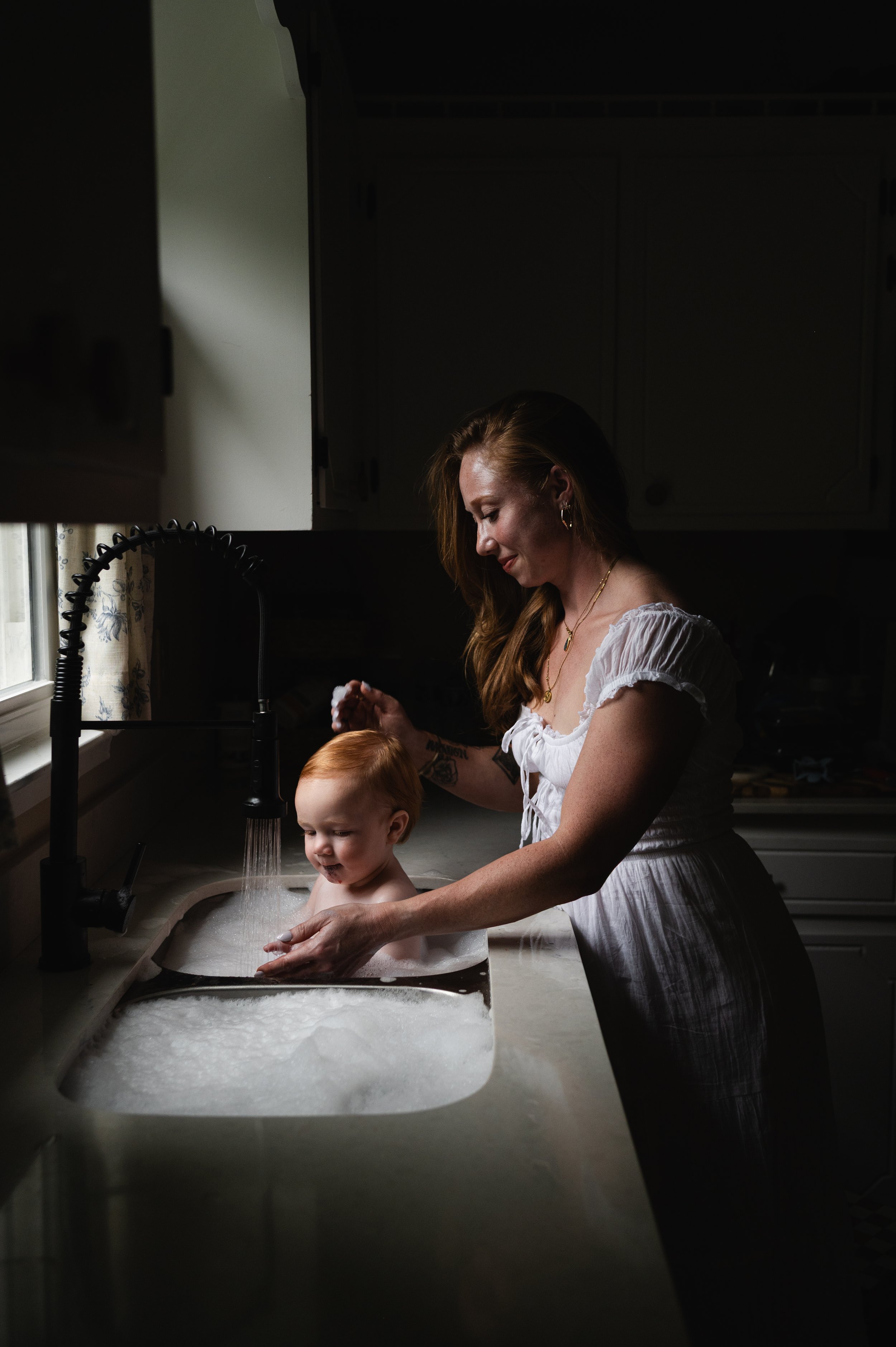 mother giving child a bath in kitchen sink, milestone, photographer, clarksville tennessee, nashville
