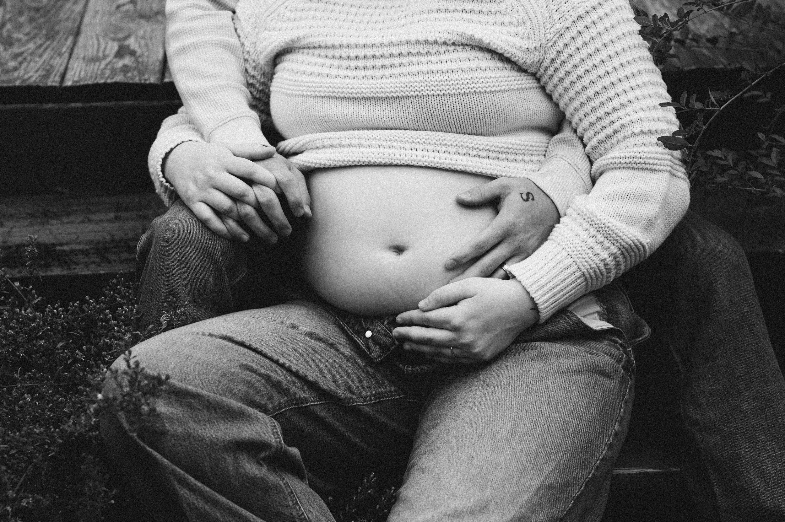 pregnant woman and husband cradle baby bump outdoors, clarksville tn, maternity photographer, nashville tn, newborn photographer, affordable, black and white, moody