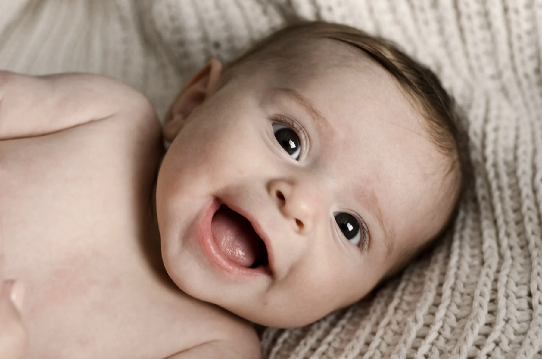 smiling three month old baby girl lays on cream knit blanket, milestone photographer, photographer, clarksville tn, nashville tn, military family, affordable, newborn photographer, family photographer