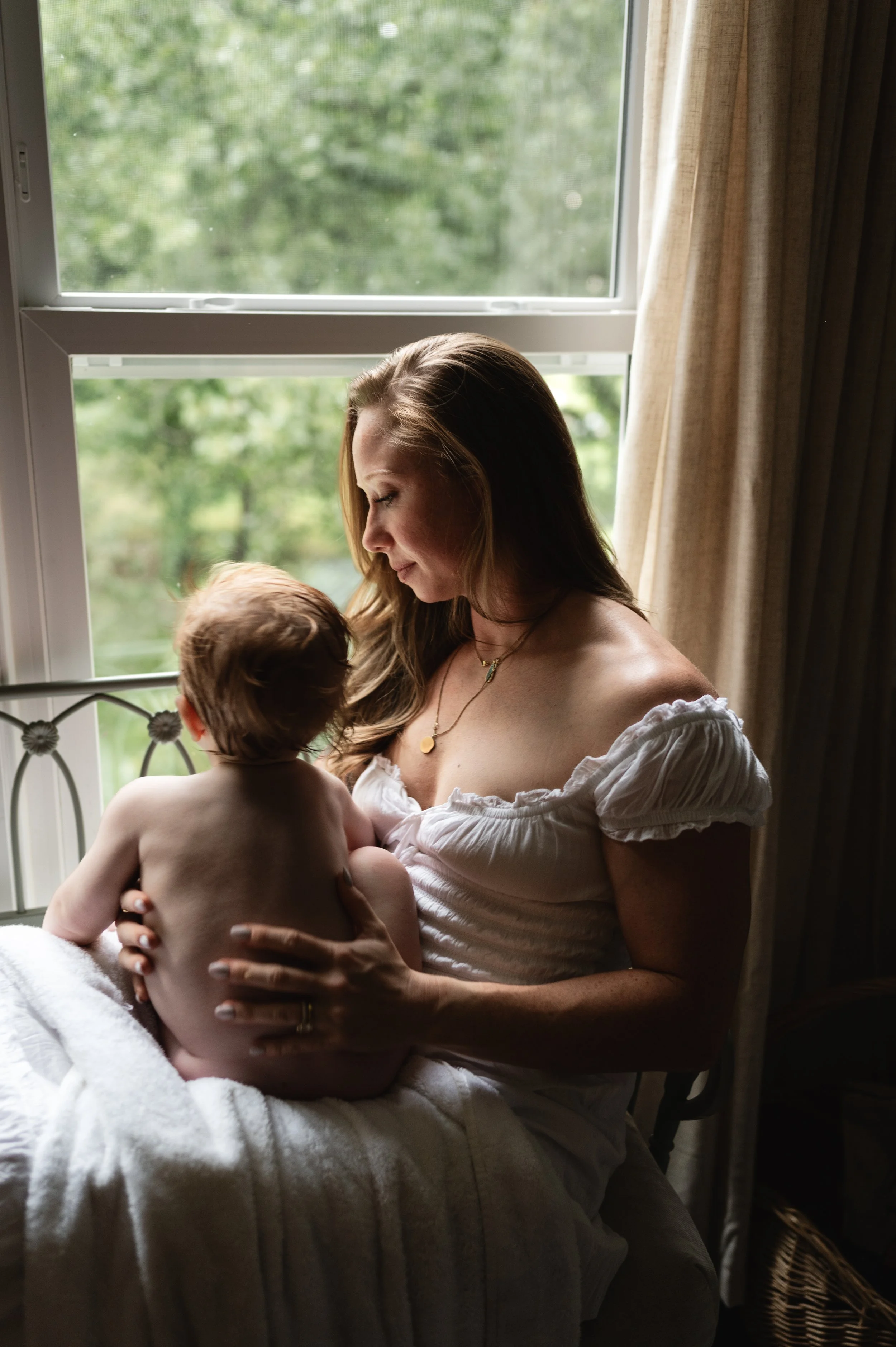 mother and baby by window with trees, family photographer, clarksville tennessee, nashville