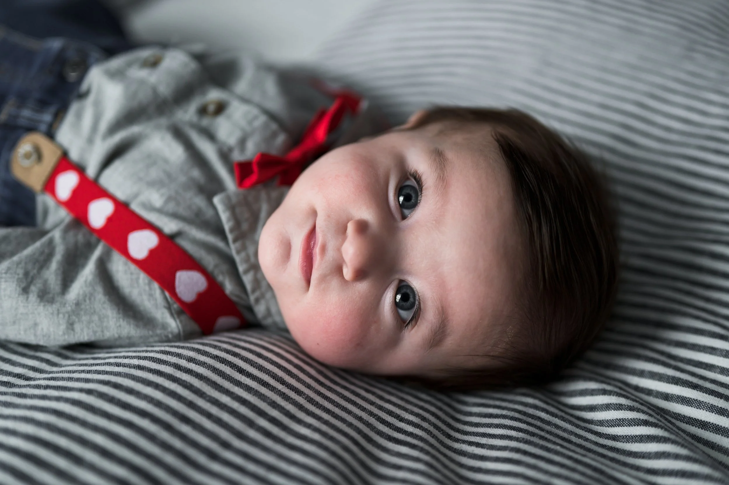 three month old boy in white and red heart suspenders lays on striped blue blanket, photographer, clarksville tennessee, nashville tennessee, newborn photographer, milestone photographer, afforable
