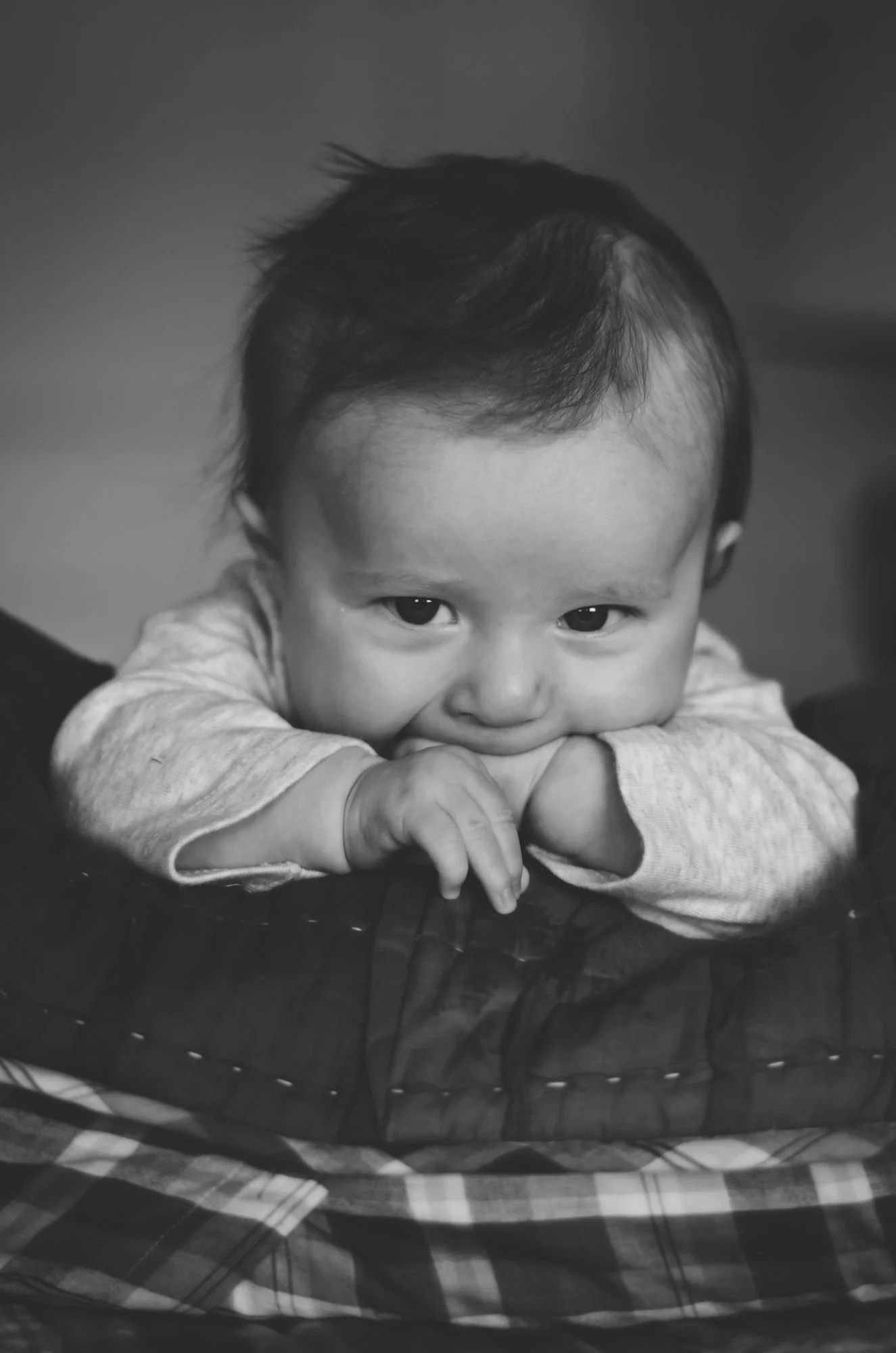 black and white photo of smiling four month old baby lays on pillow in bed, clarksville tn, nashville tn, photographer, newborn photographer, baby photographer, family and newborn, milestone, affordable