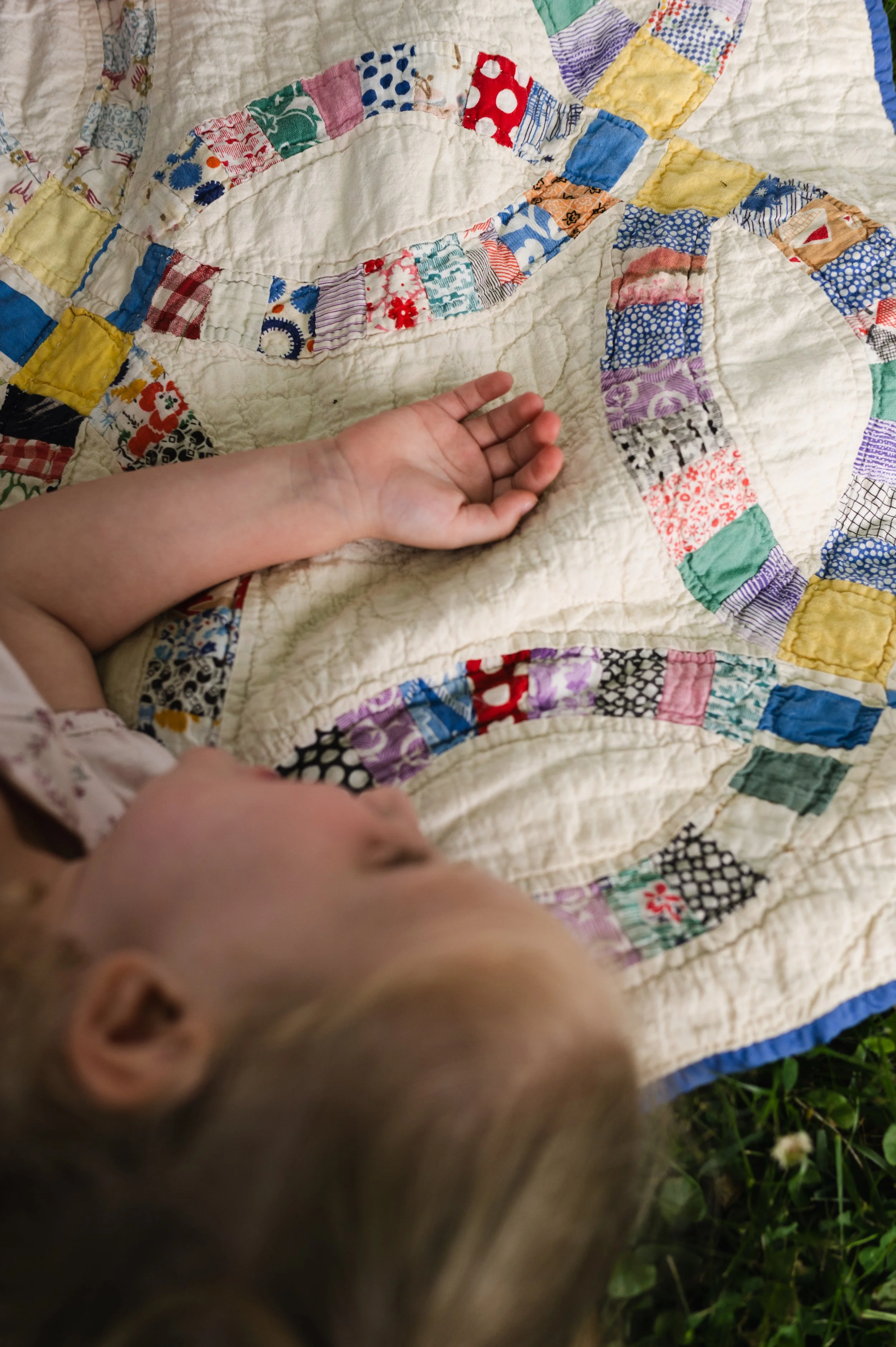 girl laying on colorful quilt, family photographer, nashville tn, affordable, clarksville tn, family photos