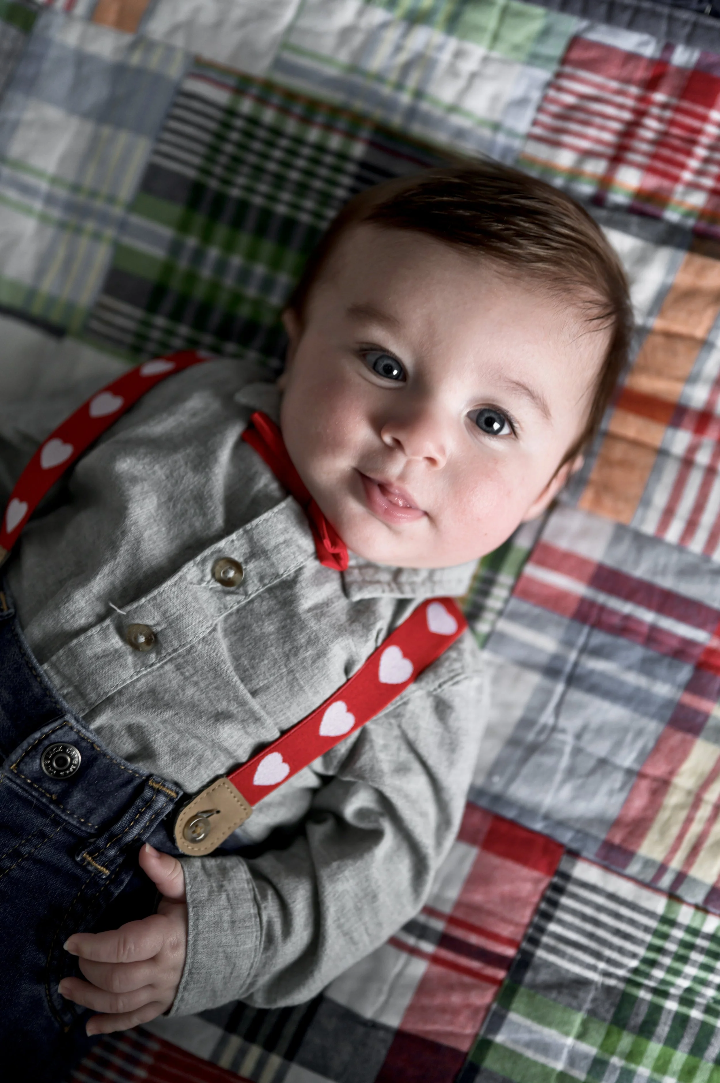 three month old baby boy in gray shirt with red suspenders lays on colorful plaid blanket, photographer, affordable, nashville tn, clarksville tn, newborn, milestone, lifestyle