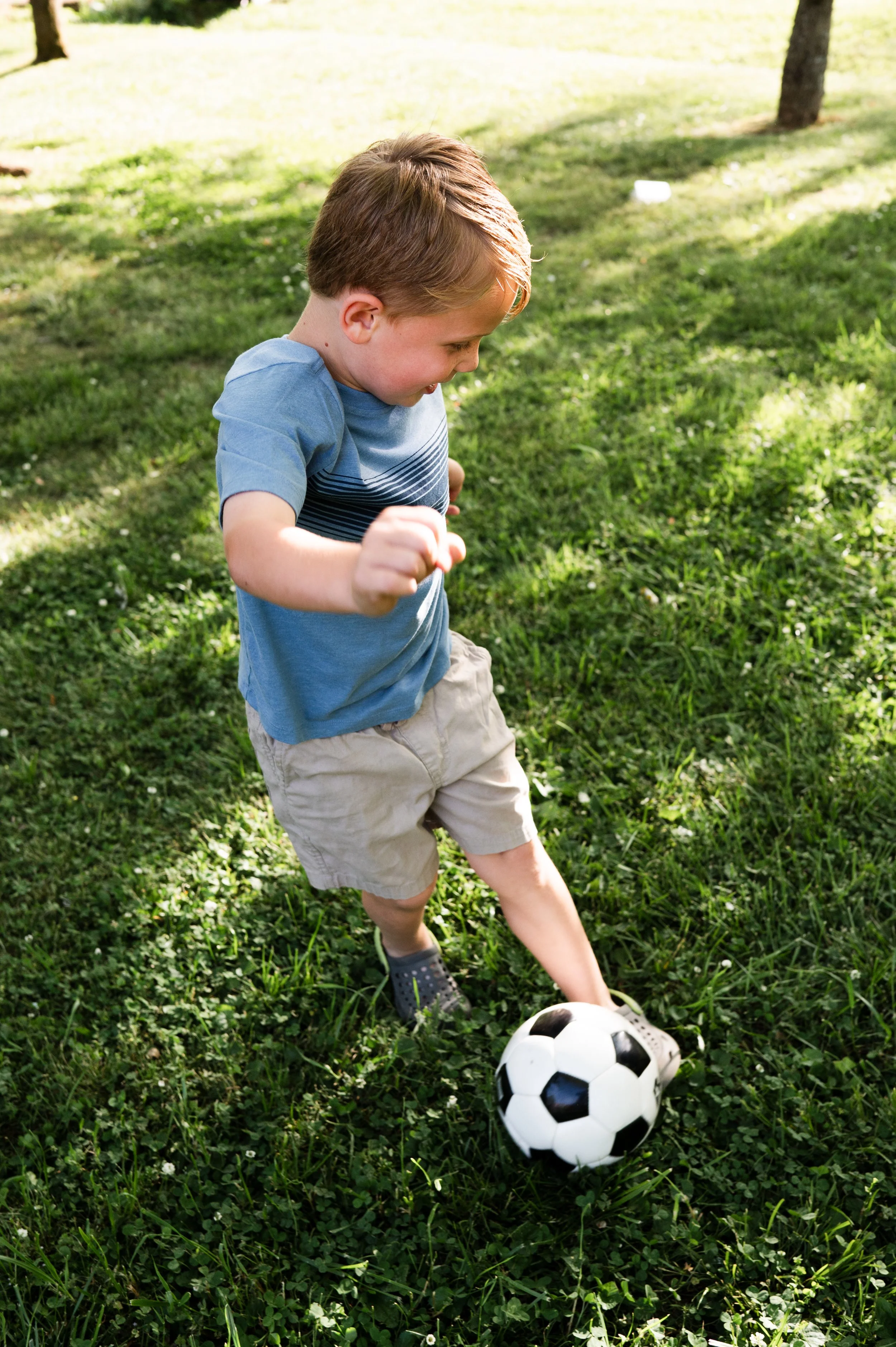 boy kicks soccer ball in yard, family photographer, clarksville tn, nashville tn, affordable, candid