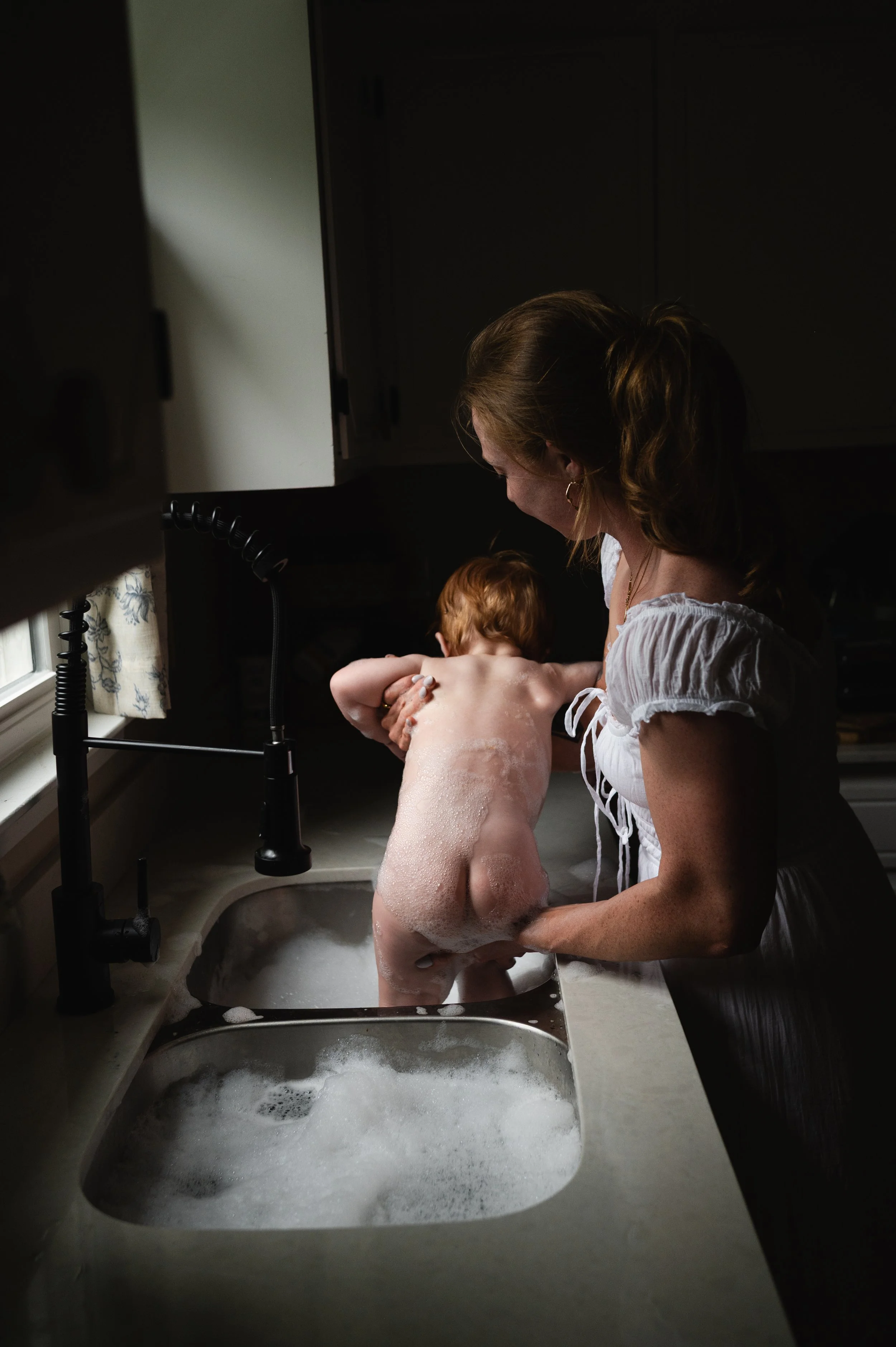 woman giving child a bath in the sink, photographer, clarksville and nashville tennessee