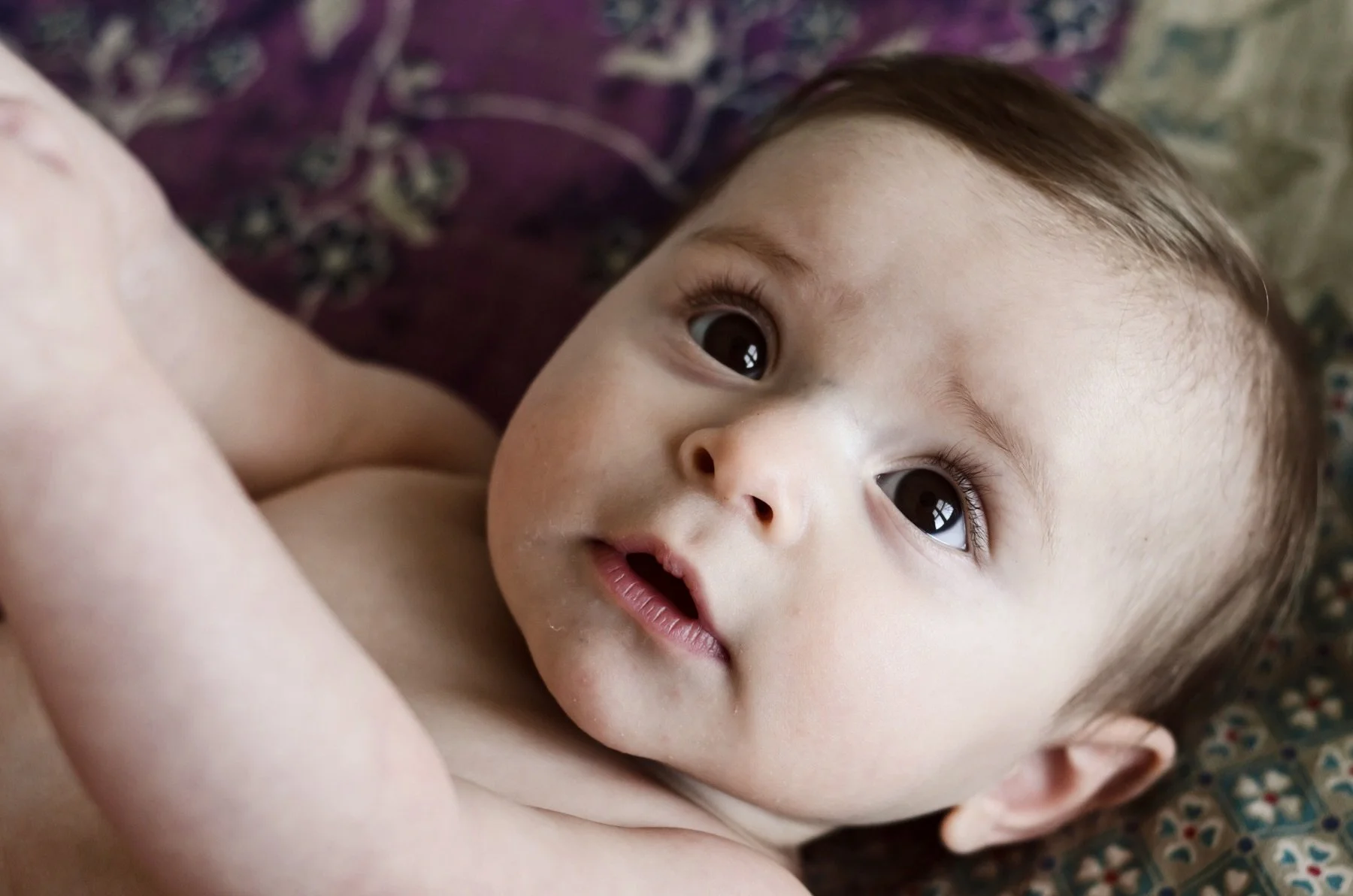 six month old baby with brown eyes and hair lays on colorful blanket, photographer, affordable, clarksville tennessee, nashville tn, newborn photographer, milestone, lifestyle, family, in-home session