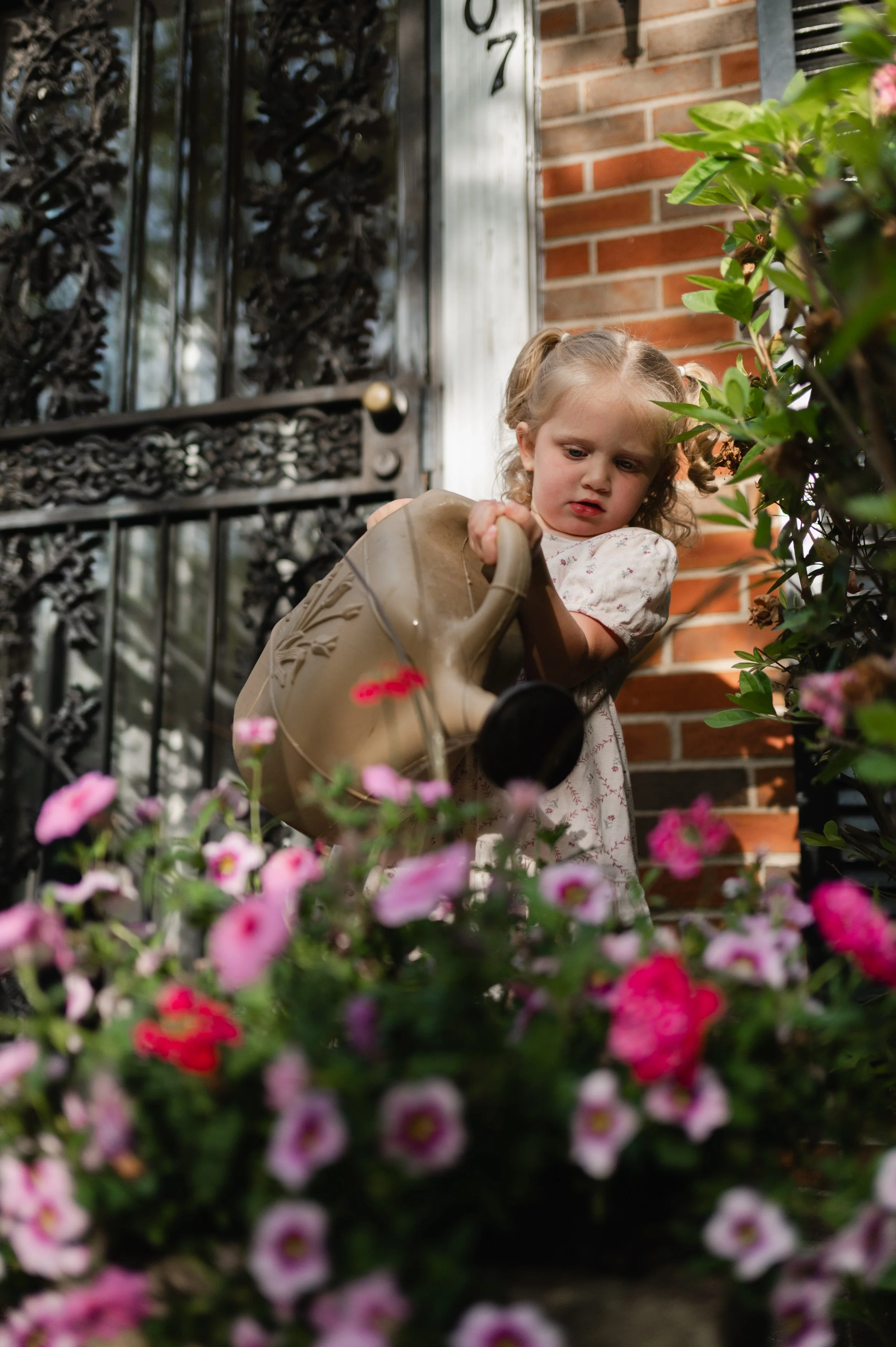 girl watering pink flowers, motherhood photographer, family photographer, affordable, clarksville tn, nashville tn