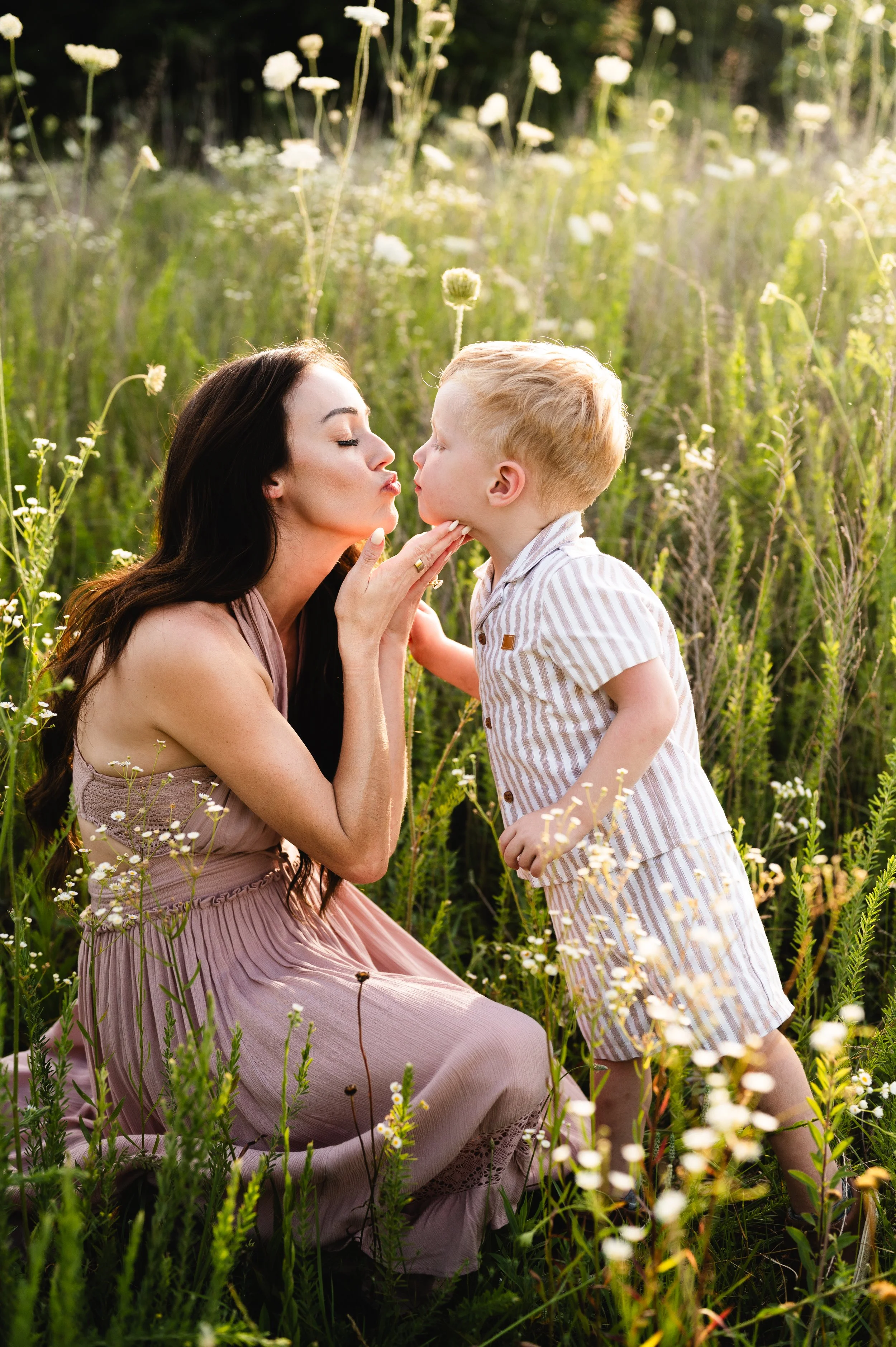 mother kissing young son in flower field, family photos, motherhood photos, photographer, clarksville tennessee