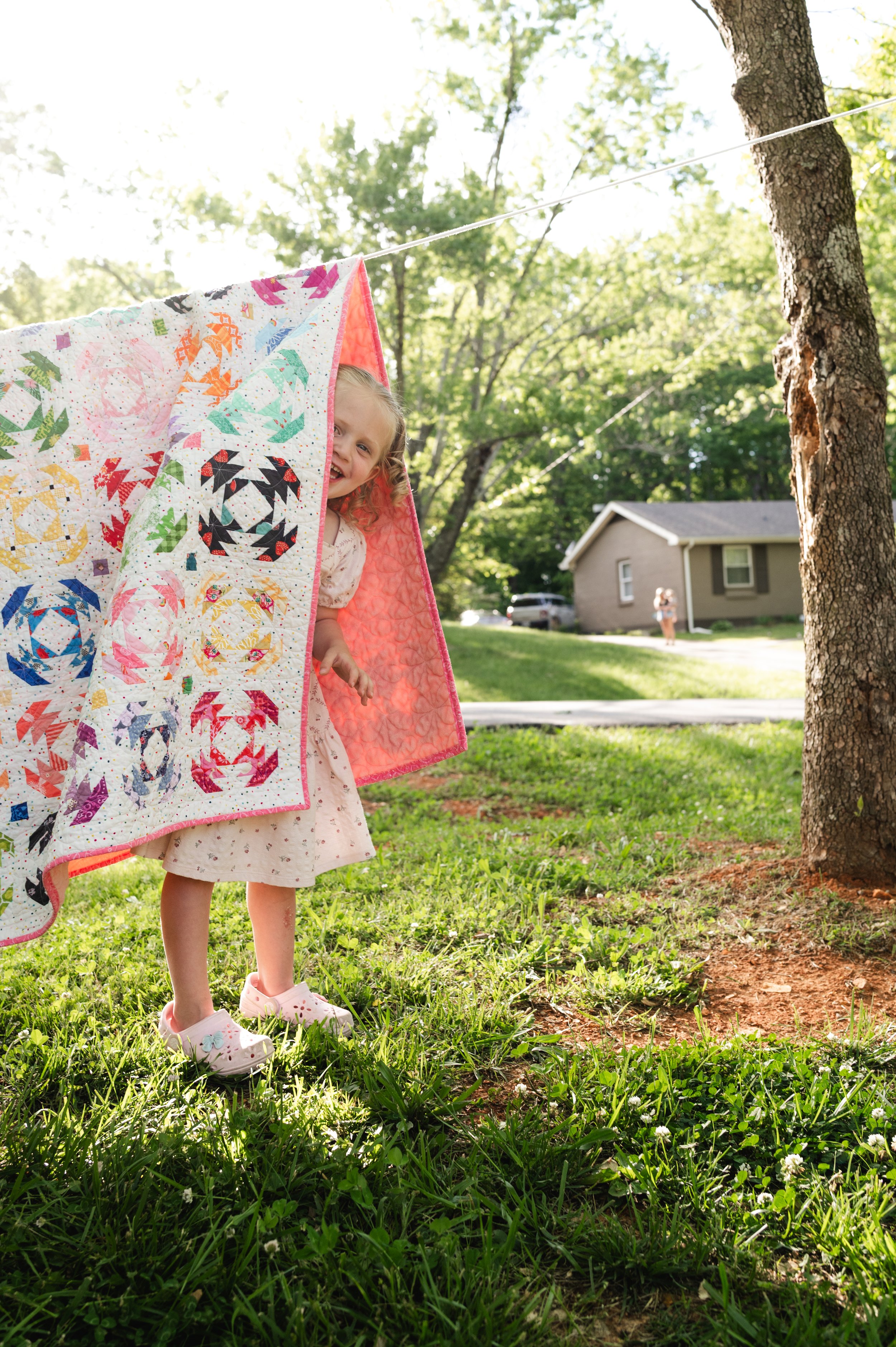 girl plays with blanket in yard, family photography, at home family session, family photographer, clarksville tn, nashville tn