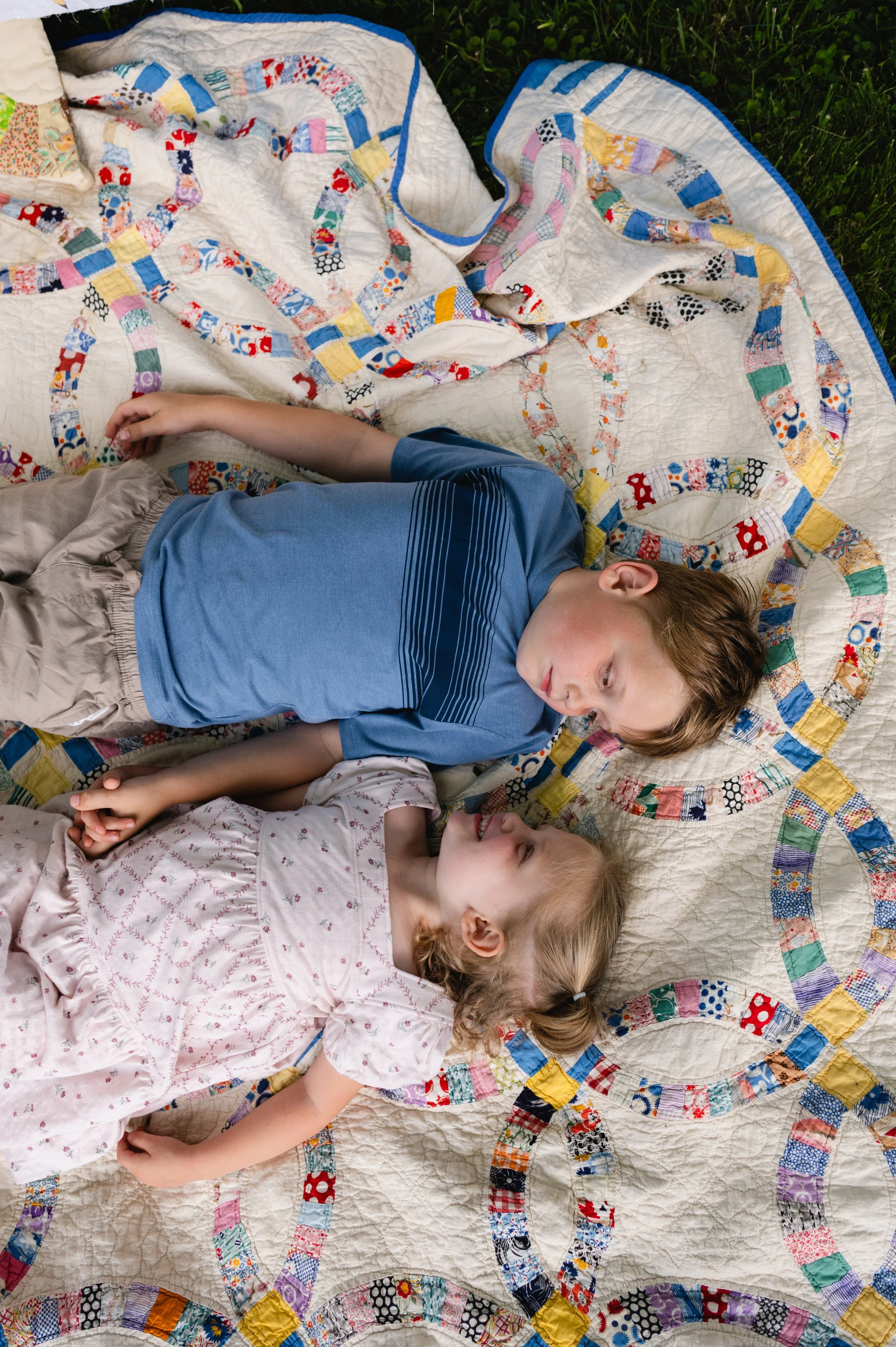 children lay on colorful quilt in yard, family photographer, clarksville tn, affordable, nashville tn