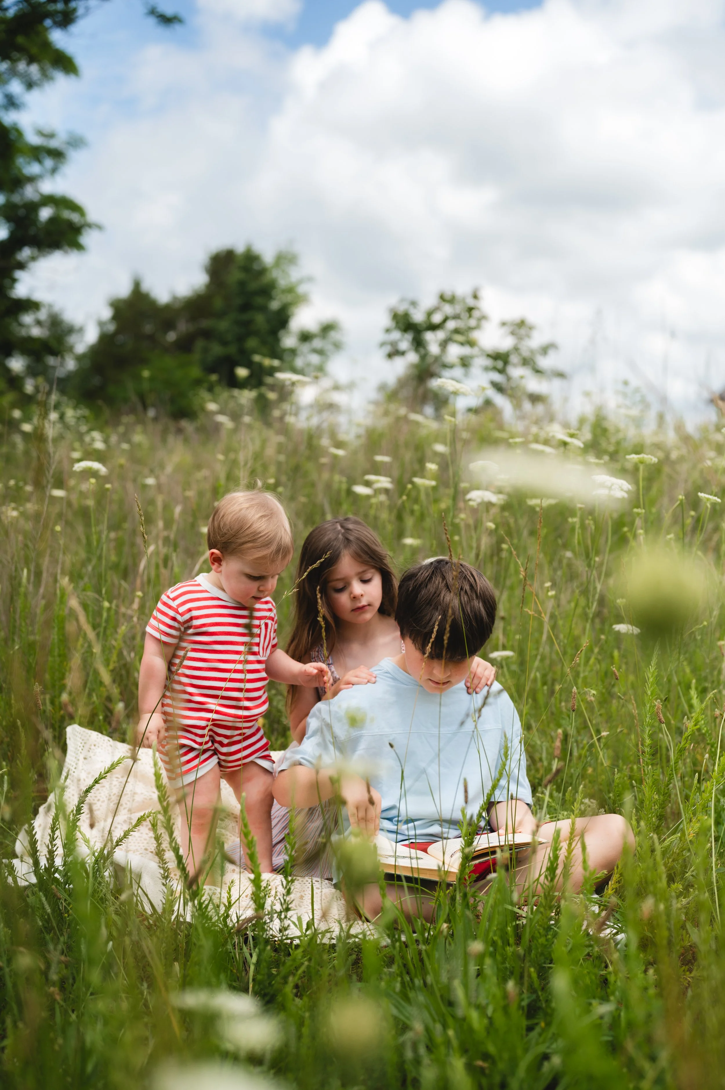 young children in flower field with clouds, family photographer, clarksville and nashville tennessee 