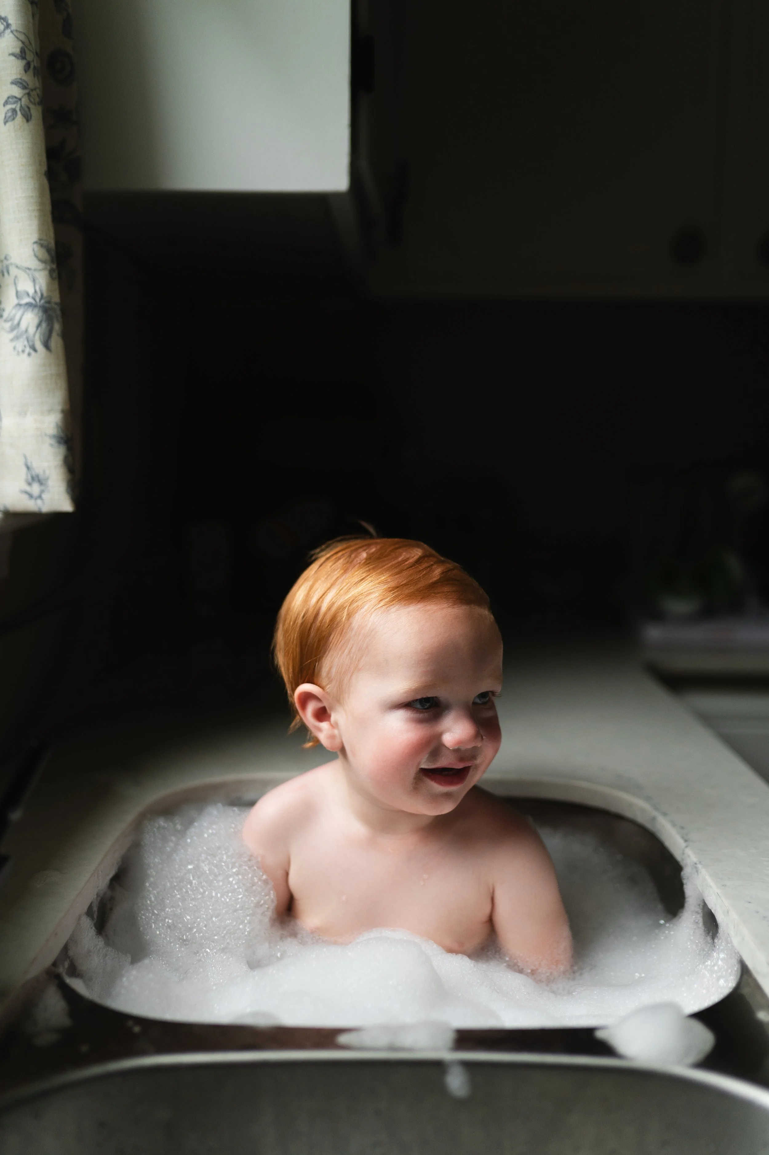 child with red hair in sink with bubbles, photographer, milestone, birthday, clarksville and nashville tennessee