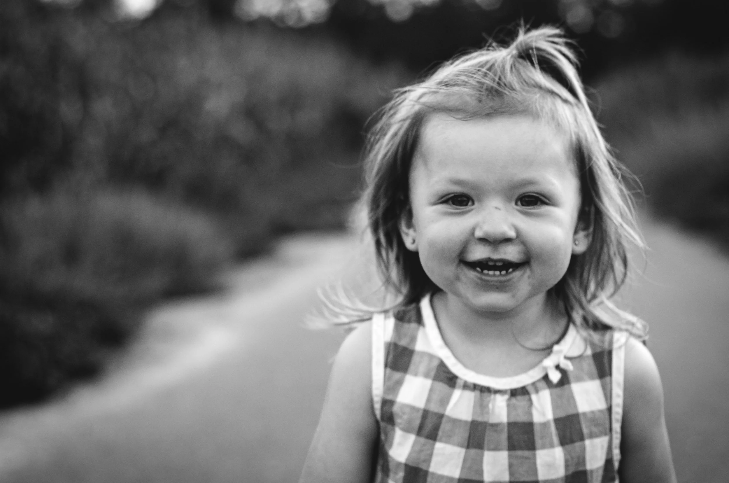 black and white photo of smiling young girl walks down road along cornfield, photographer, affordable, clarksville tn, nashville tn, film photographer, family photographer