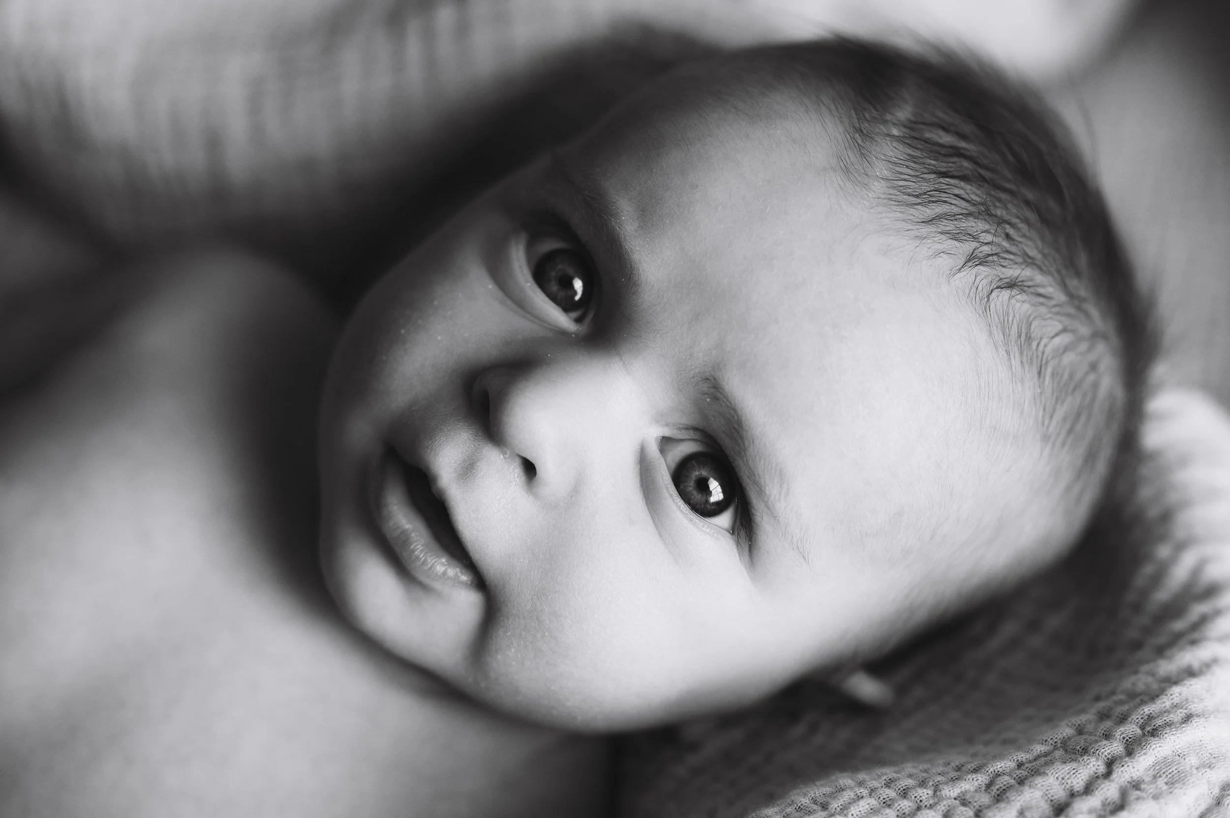 moody black and white portrait of three month old boy laying on white muslin blanket, photographer, affordable, clarksville tennessee, nashville tennessee, newborn photographer, milestone portrait
