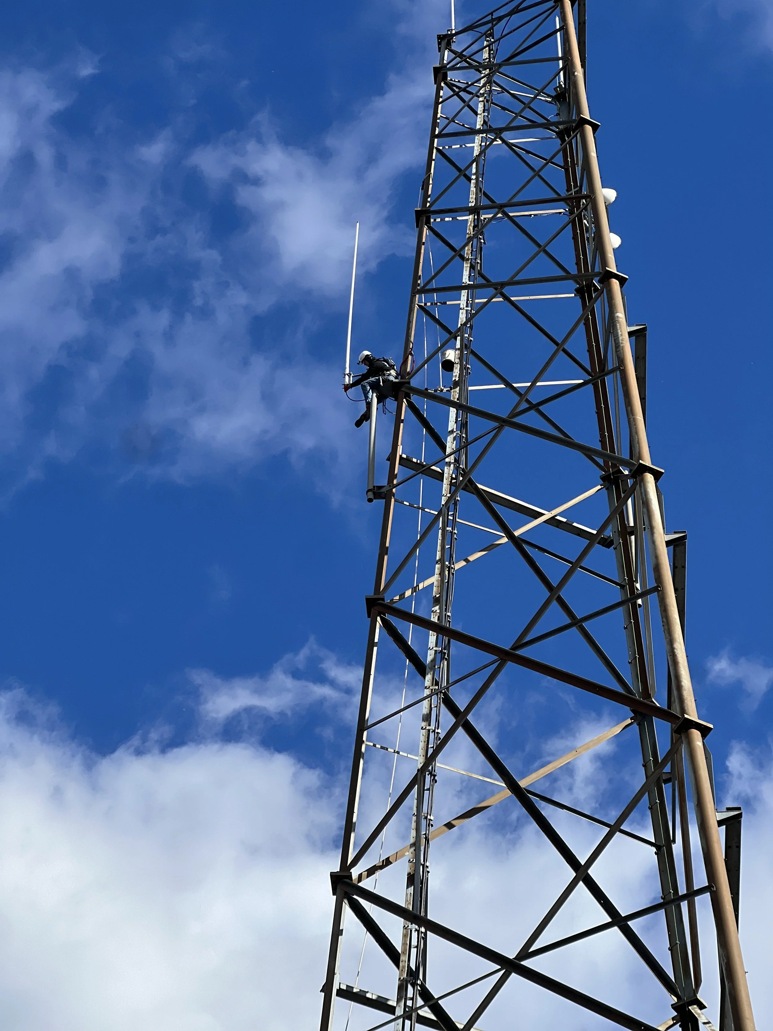 Certified climber ascending active communications tower — VCTowers LLC tower operations