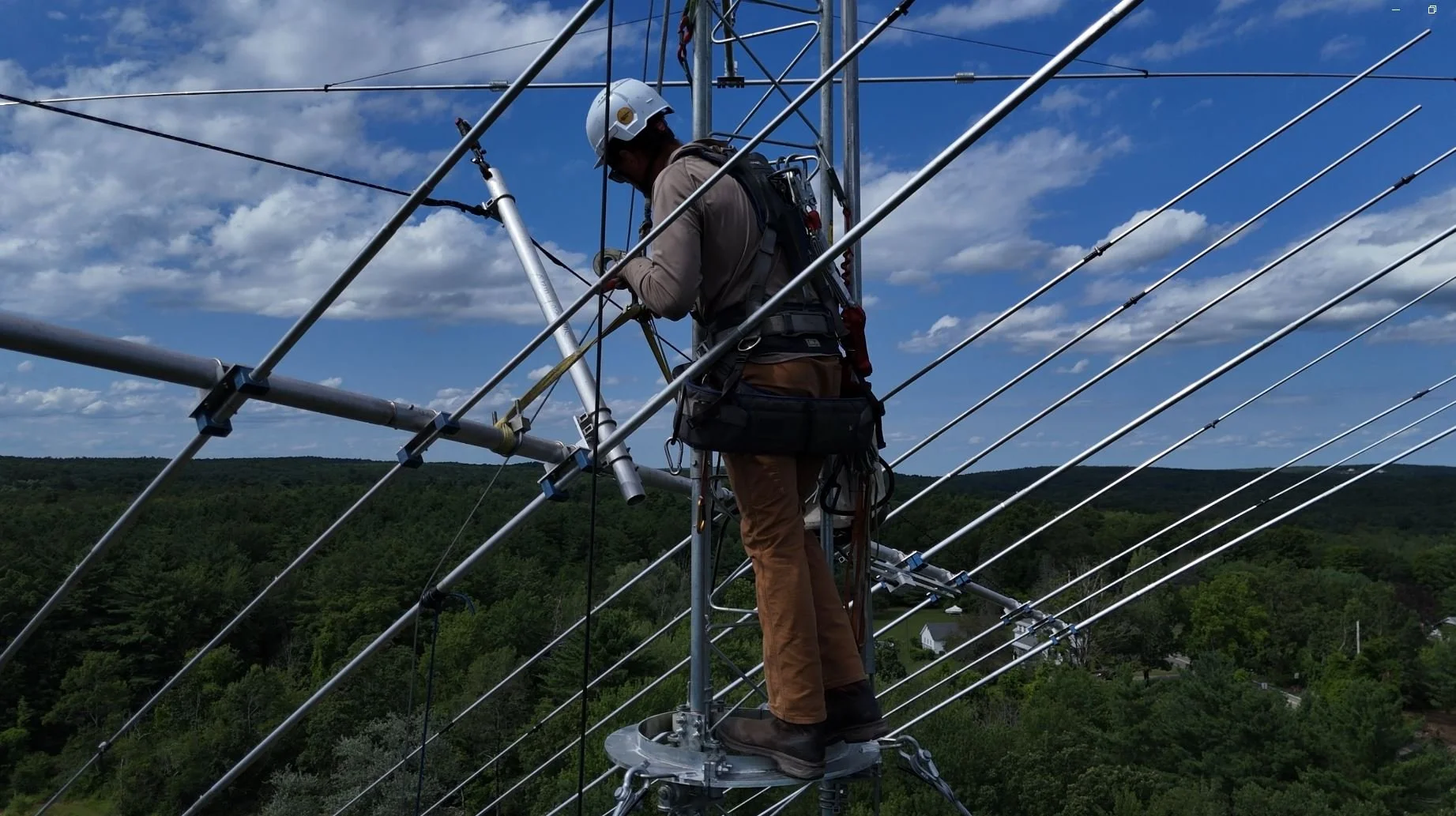 Certified tower climber installing HF Yagi antenna elements at height — ham radio antenna installation contractor New England and nationwide