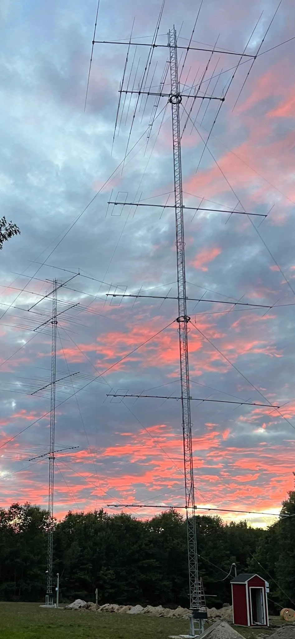 Dual Rohn 55G rotating tower build at sunset — twin guyed tower installation with 403A rotating ring assemblies, Casco ME