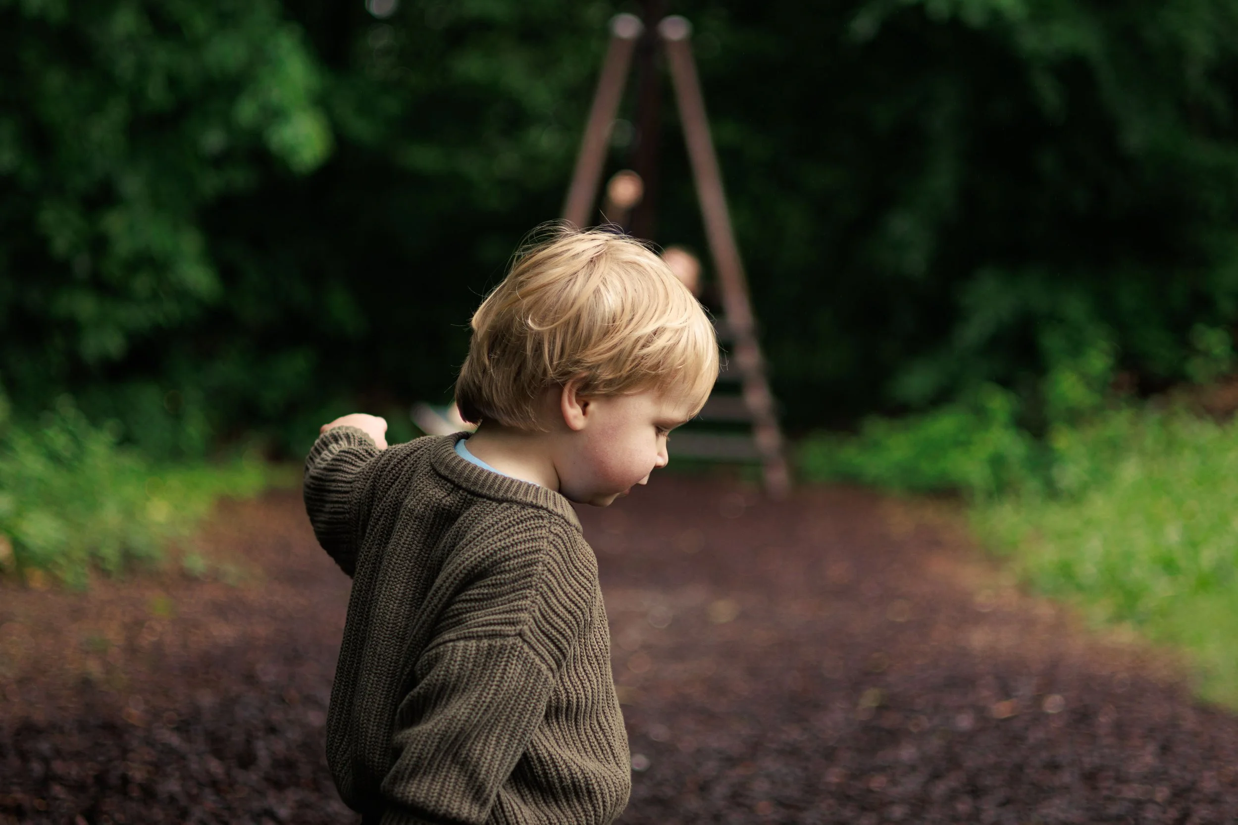 A candid shot of a young boy on a playground, just beginning to walk and discovering his own stride.