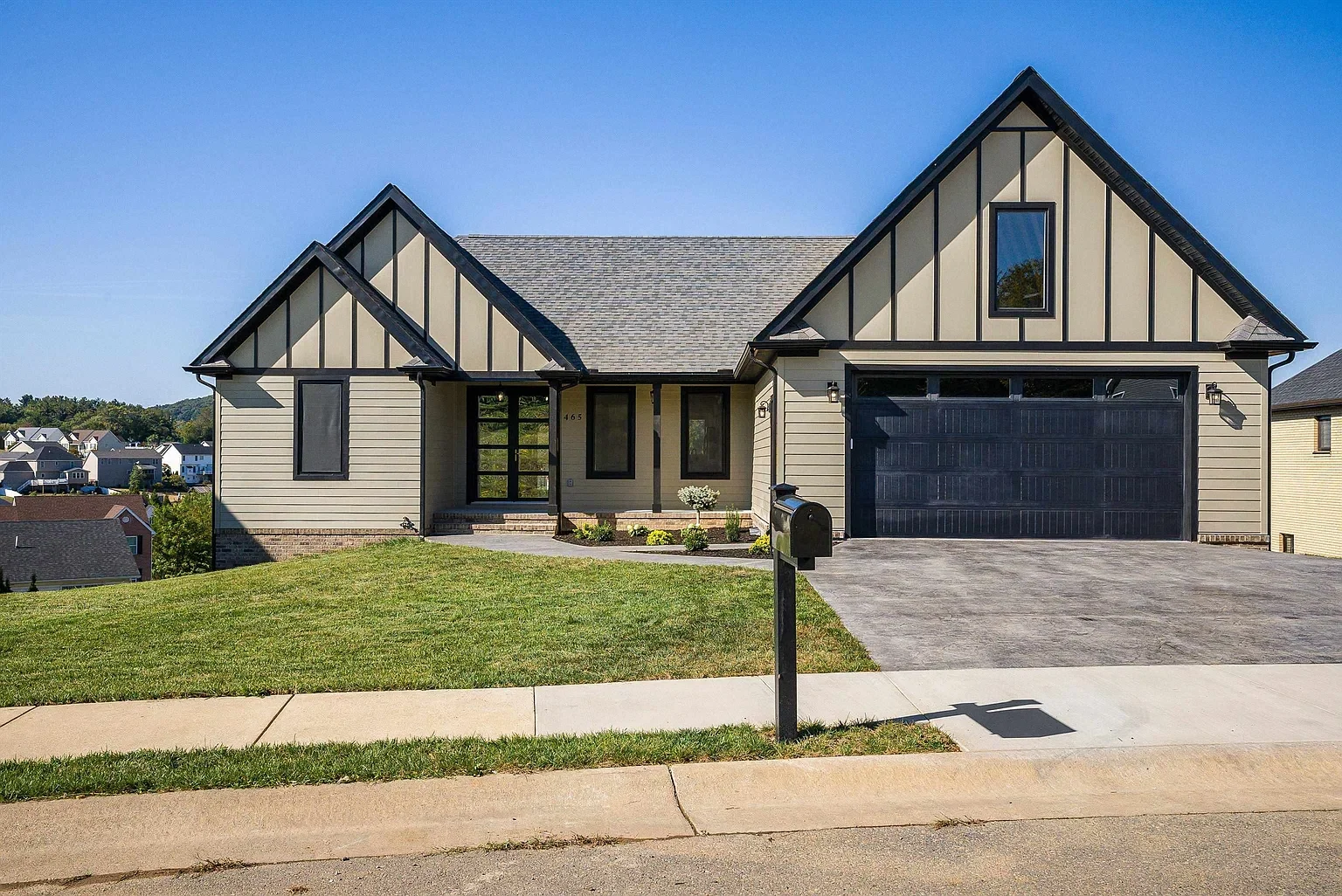 Modern suburban house with a black garage door.